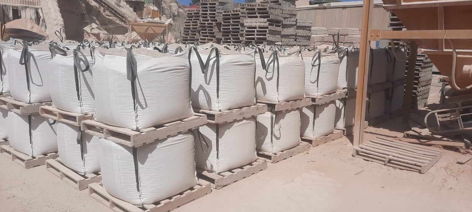 Excavadora amarilla cavando una zanja profunda en un campo de hierba en un día soleado.