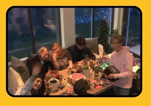 Una familia está sentada en una mesa comiendo comida.