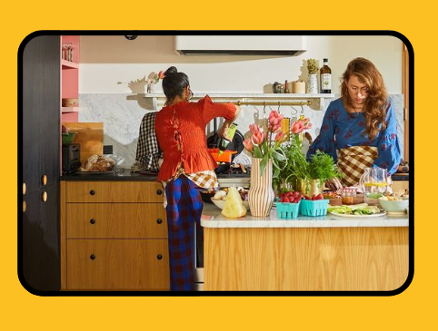Dos mujeres están cocinando en una cocina en la pantalla de un teléfono celular.
