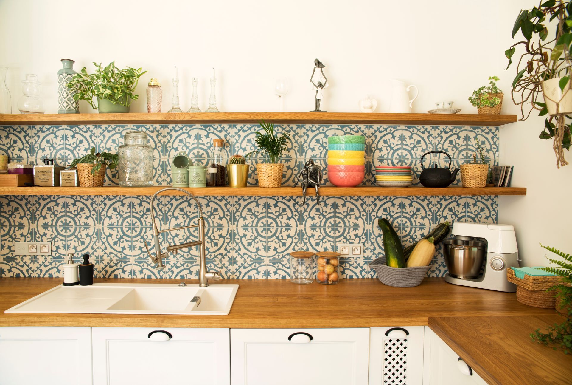 Plan de travail en bois avec lavabo, étagères et crédence en mosaïque.