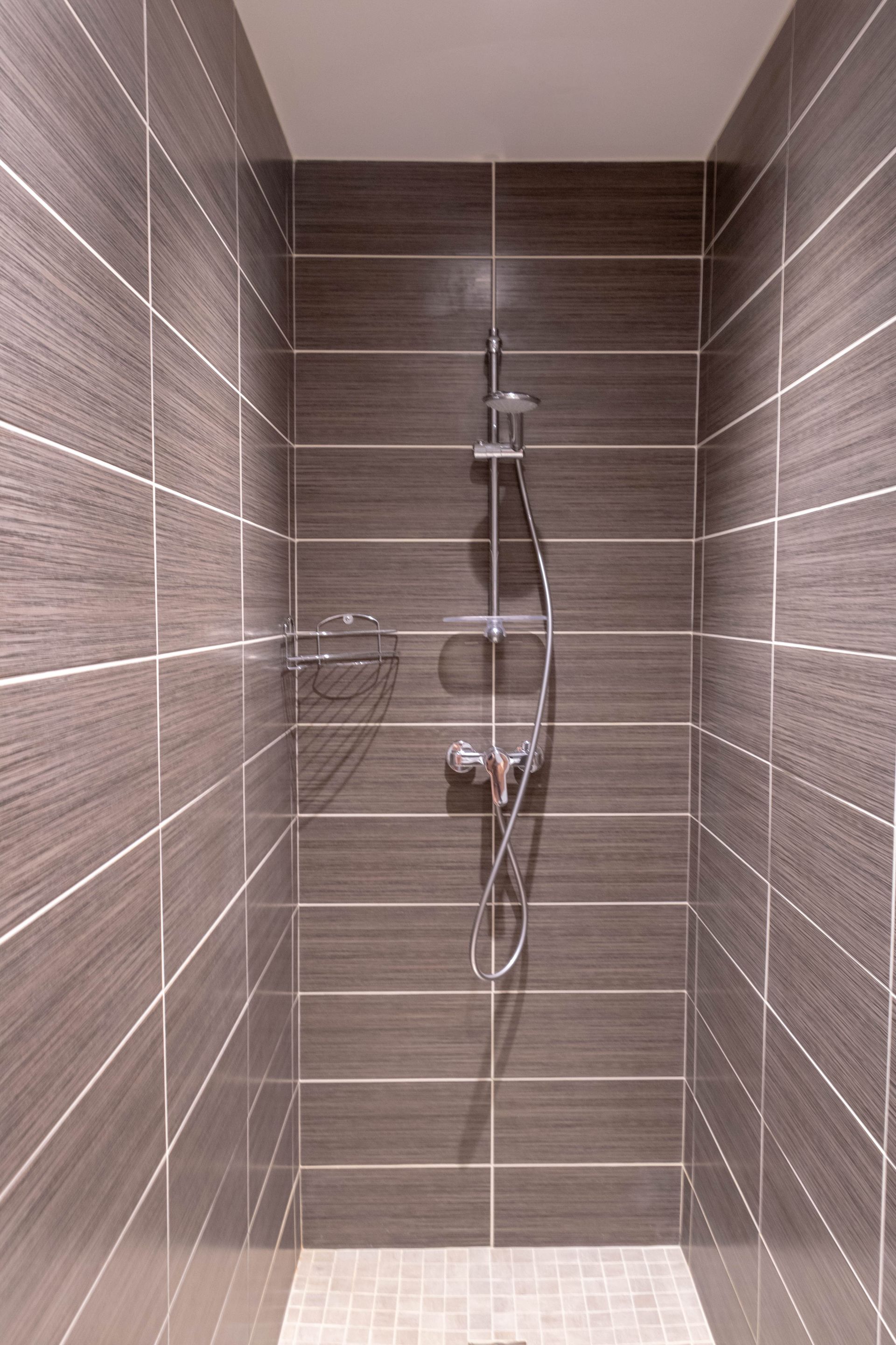 Douche à l'italienne moderne carrelée avec niches de rangement intégrées.