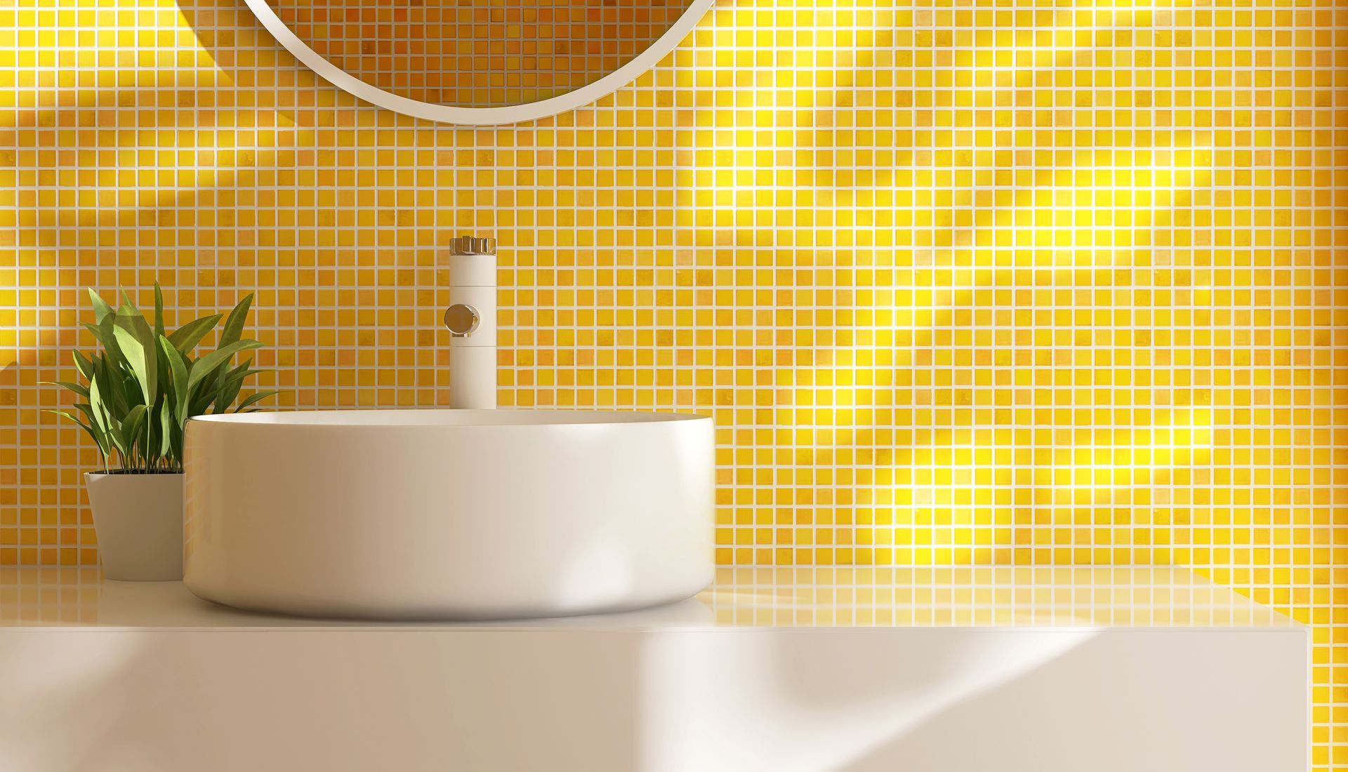 Un lavabo blanc sur un comptoir beige, devant un mur en mosaïque jaune vif.