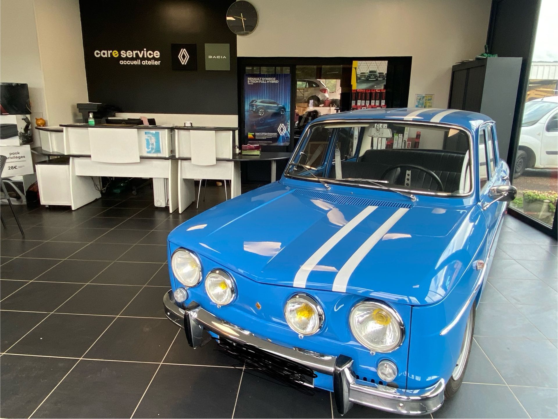 Rangée de voitures colorées garées sur le parking d'un concessionnaire. Véhicules orange, rouge, noir et bleu en plein jour.