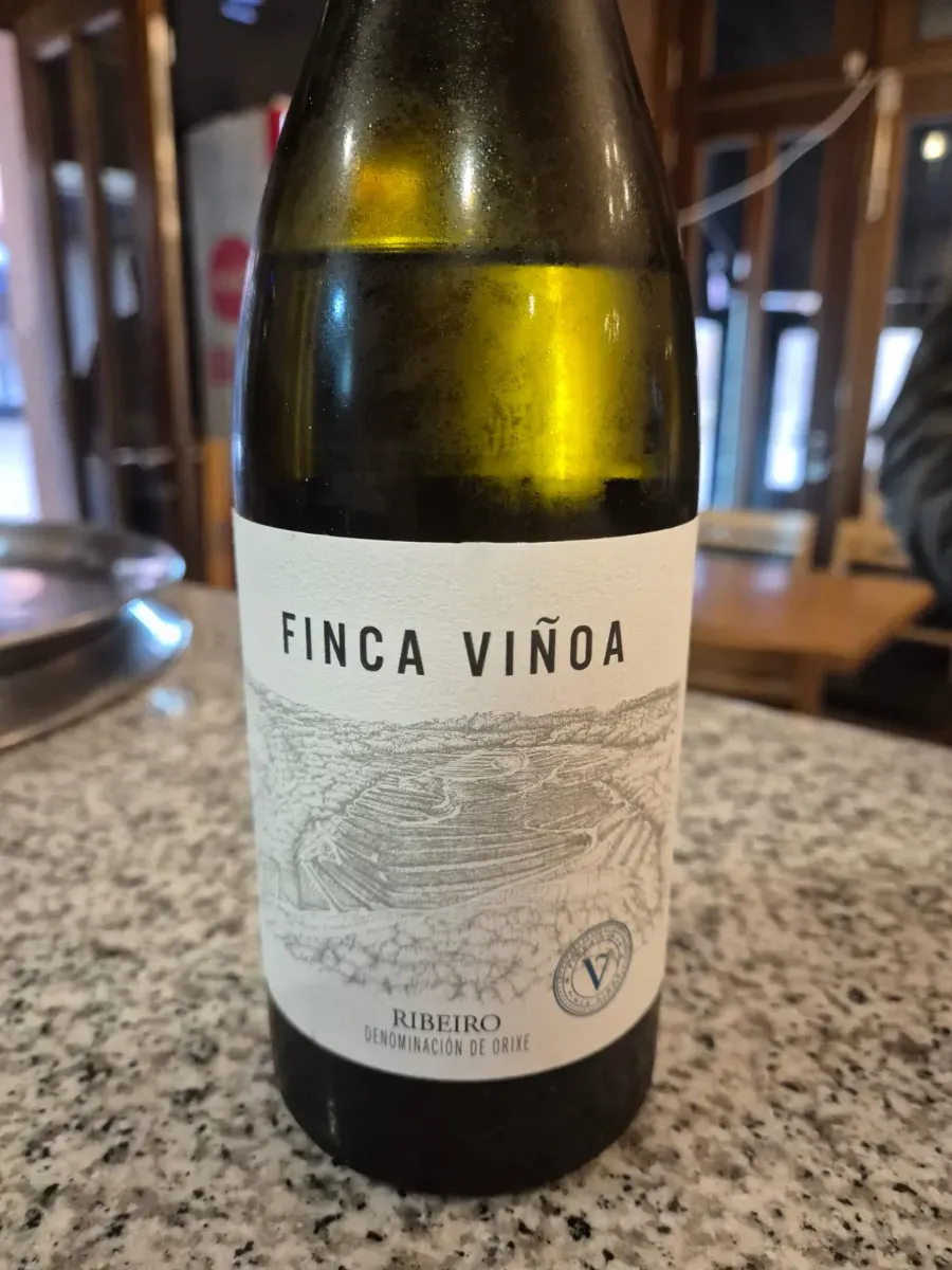 Botella de vino Finca Viñoa sobre la barra de un bar, con la etiqueta hacia adelante.