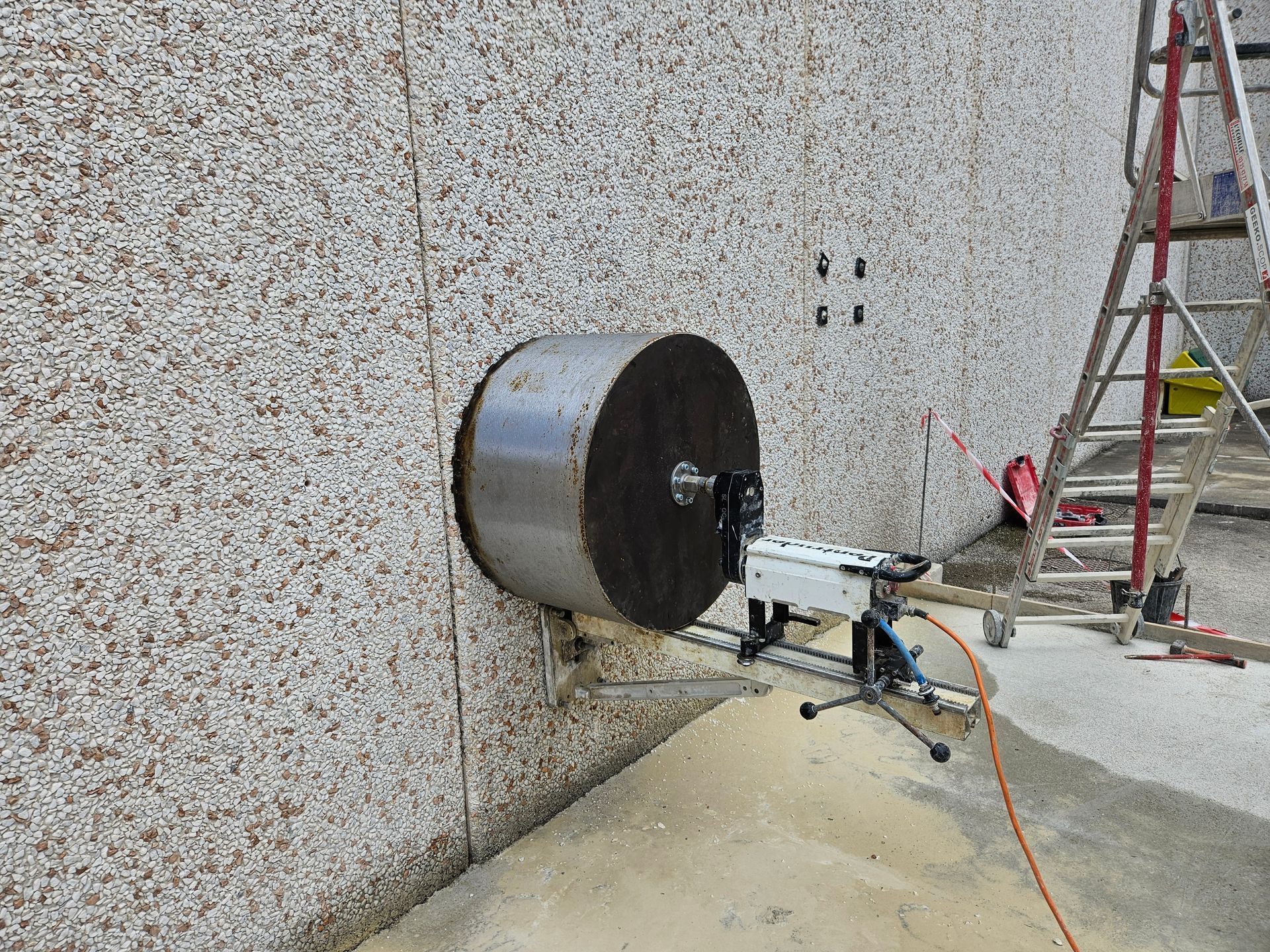 Grosse perceuse perçant un trou dans un mur.