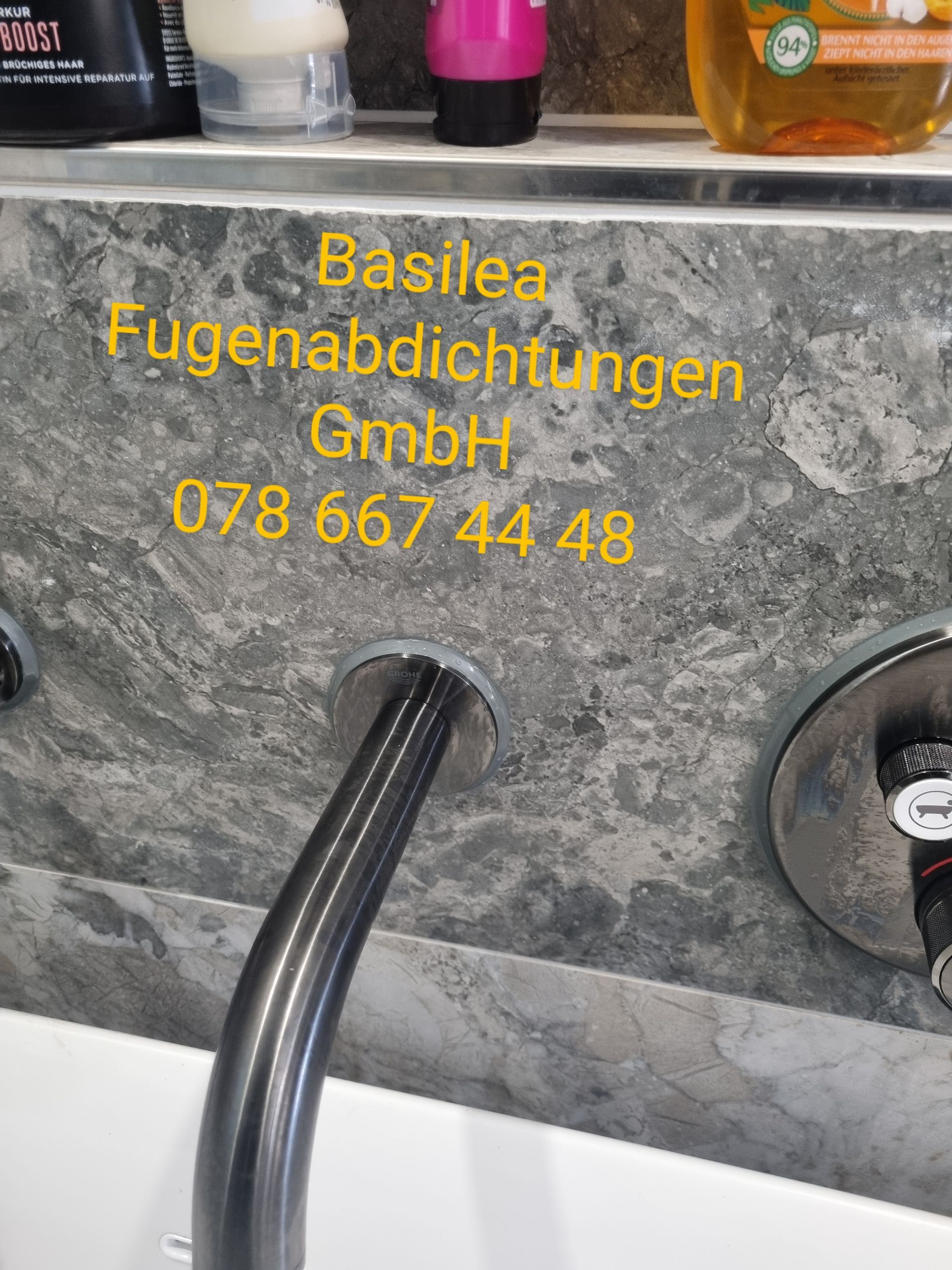 Ein Waschbecken mit Wasserhahn und einem Schild mit der Aufschrift „Basilea Fugenabdichtungen GmbH“