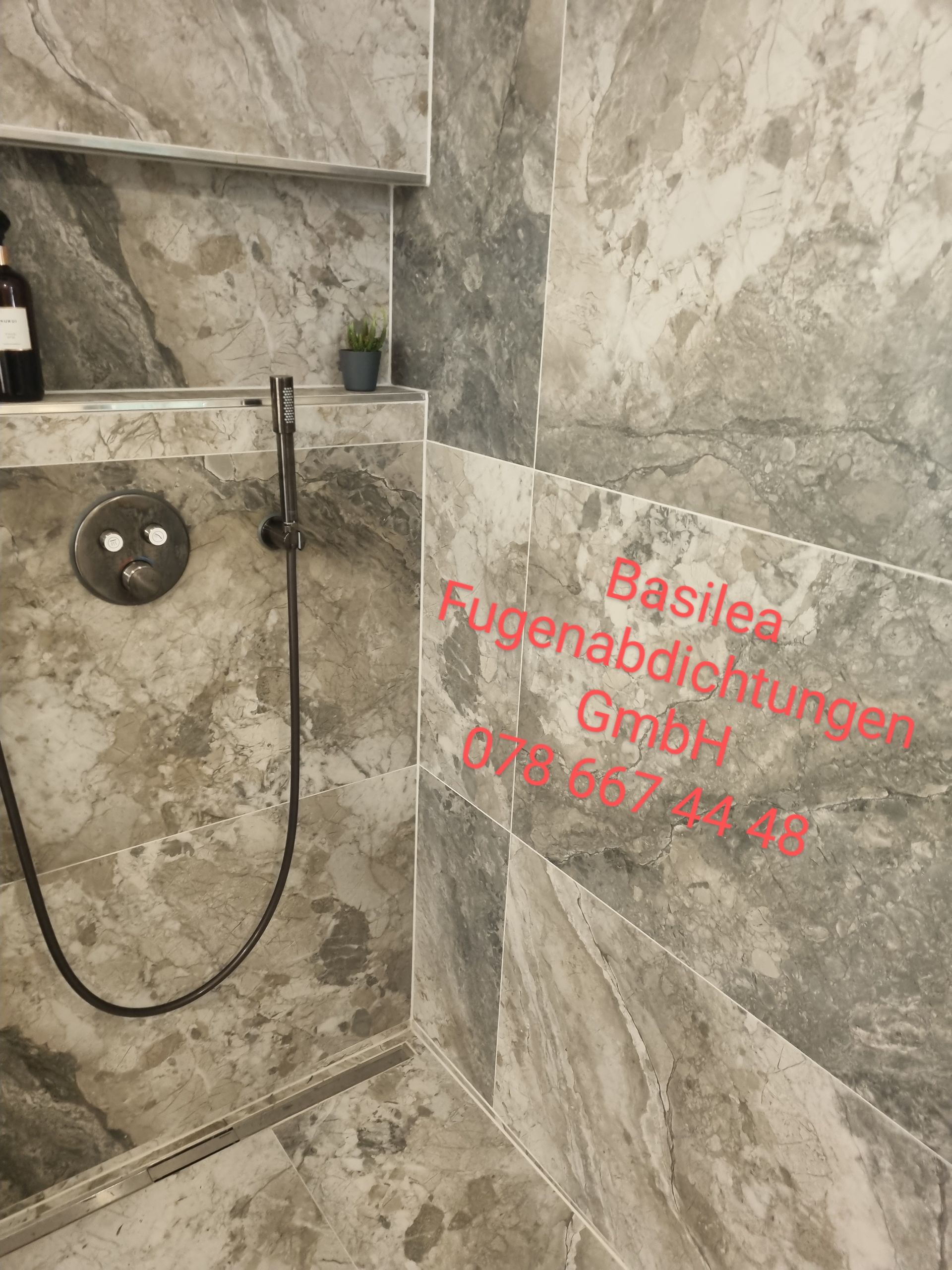 Eine Dusche mit angeschlossenem Schlauch in einem Badezimmer.