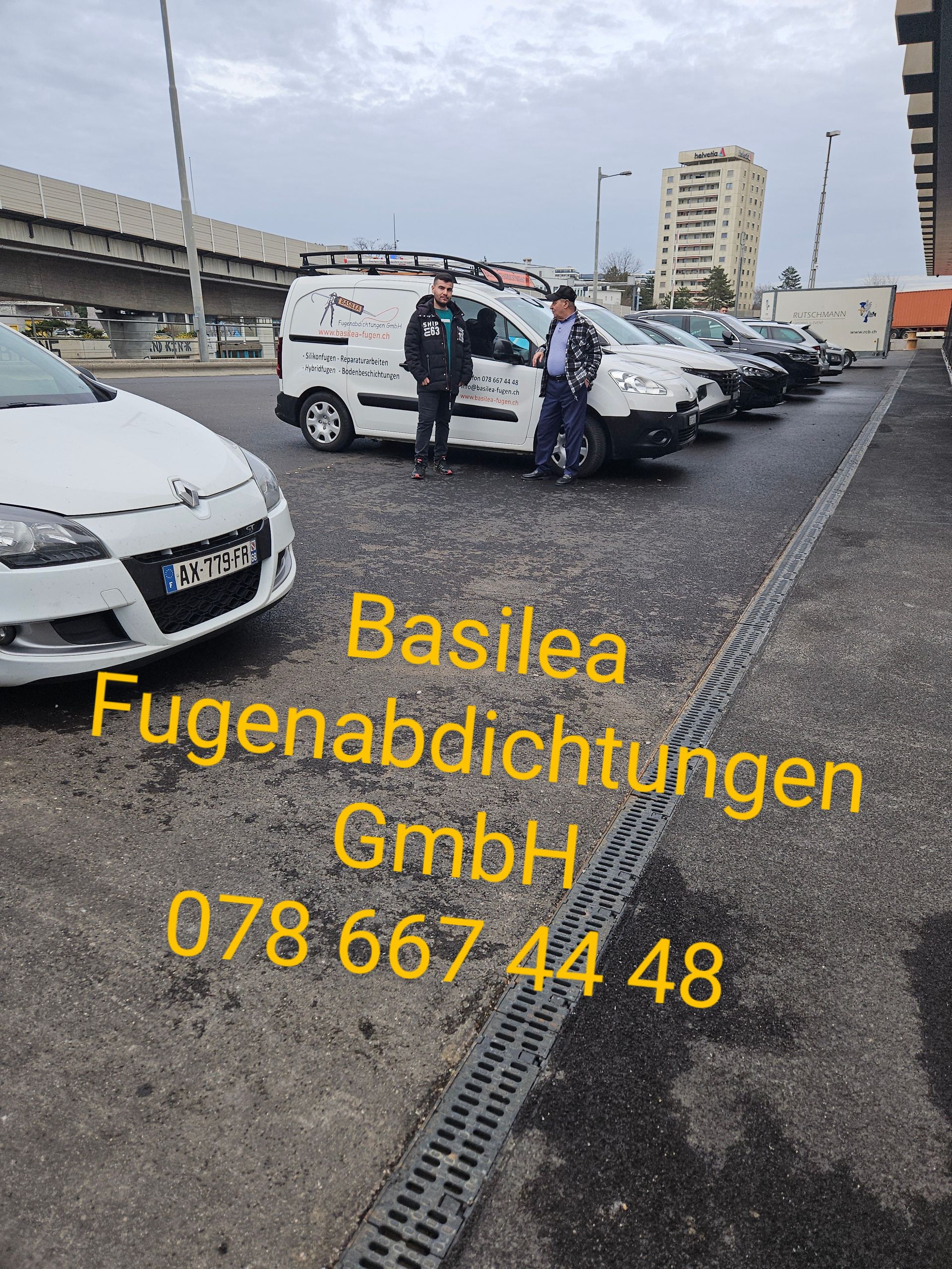 Eine Gruppe von Menschen steht vor einer Reihe von Autos.