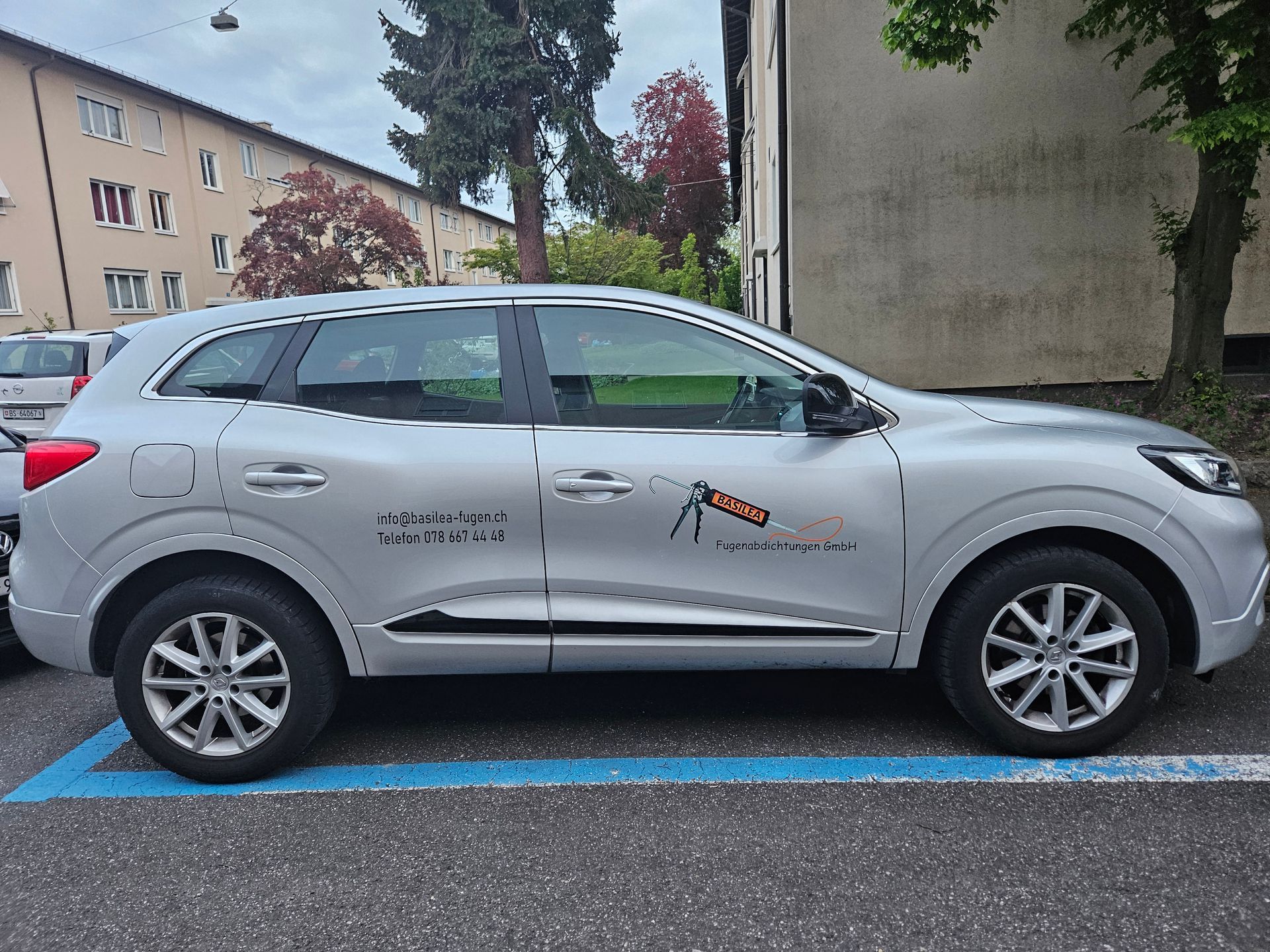 Ein silbernes Auto steht auf einem Behindertenparkplatz.