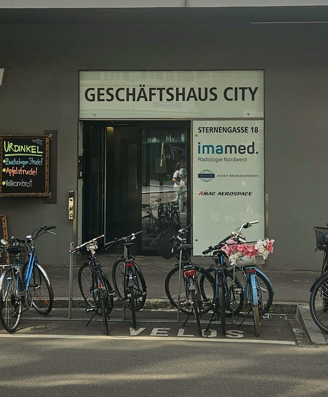 Mehrere Fahrräder sind vor dem Geschäftshaus City geparkt