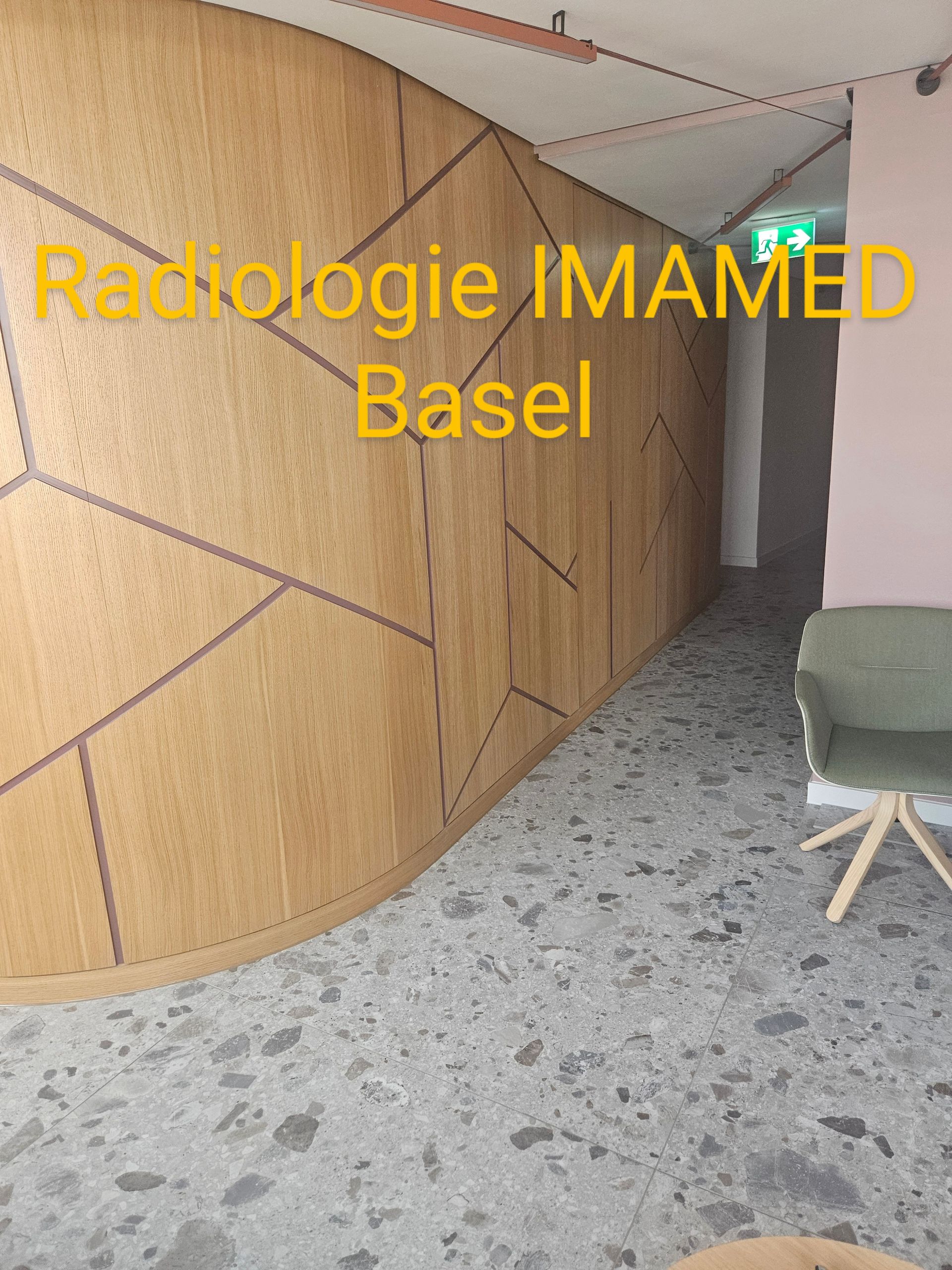 Ein Flur mit einem Stuhl und einem Schild mit der Aufschrift „Radiologie Imamed Basel“