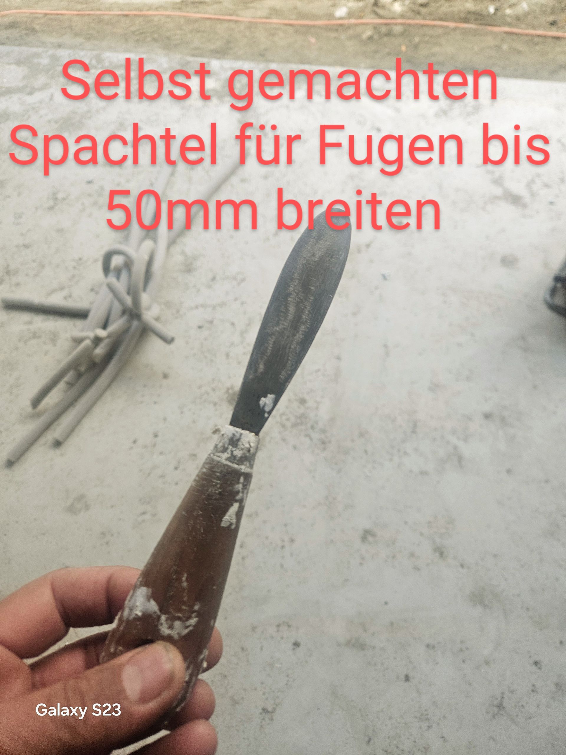 Eine Person hält einen 50 mm langen Spatel