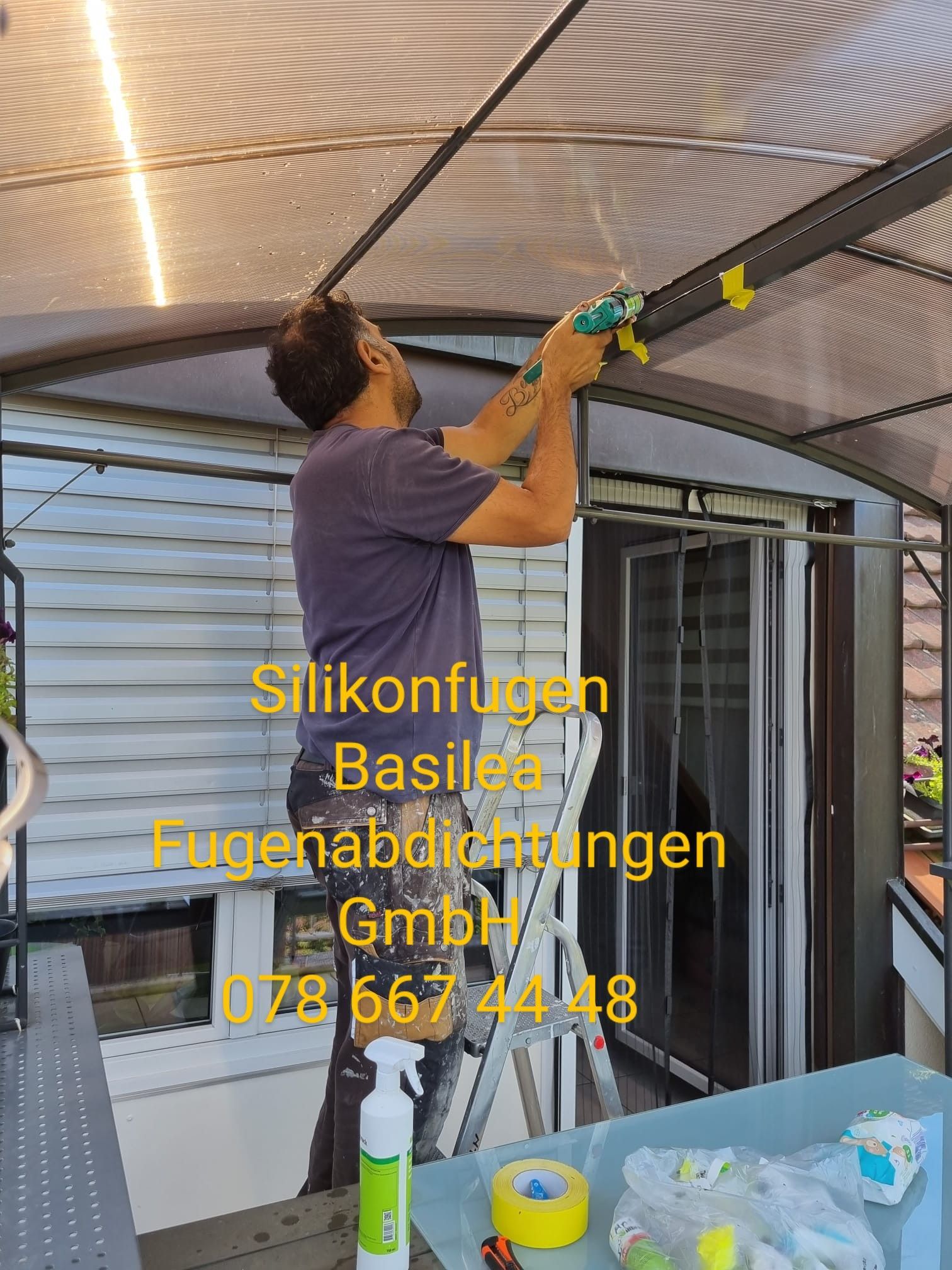 Ein Mann steht auf einer Leiter und arbeitet auf einem Dach.