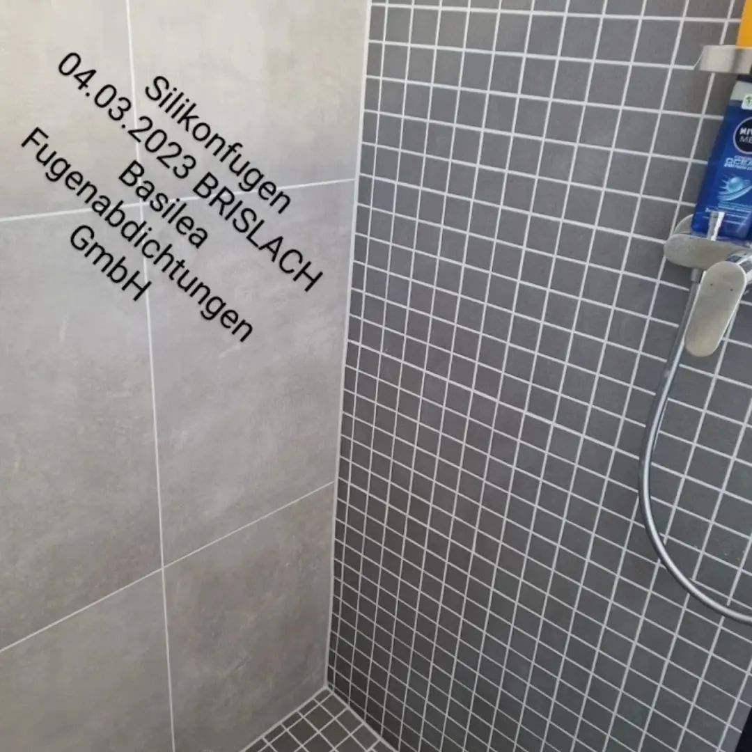 Eine Dusche mit gefliester Wand und Duschkopf