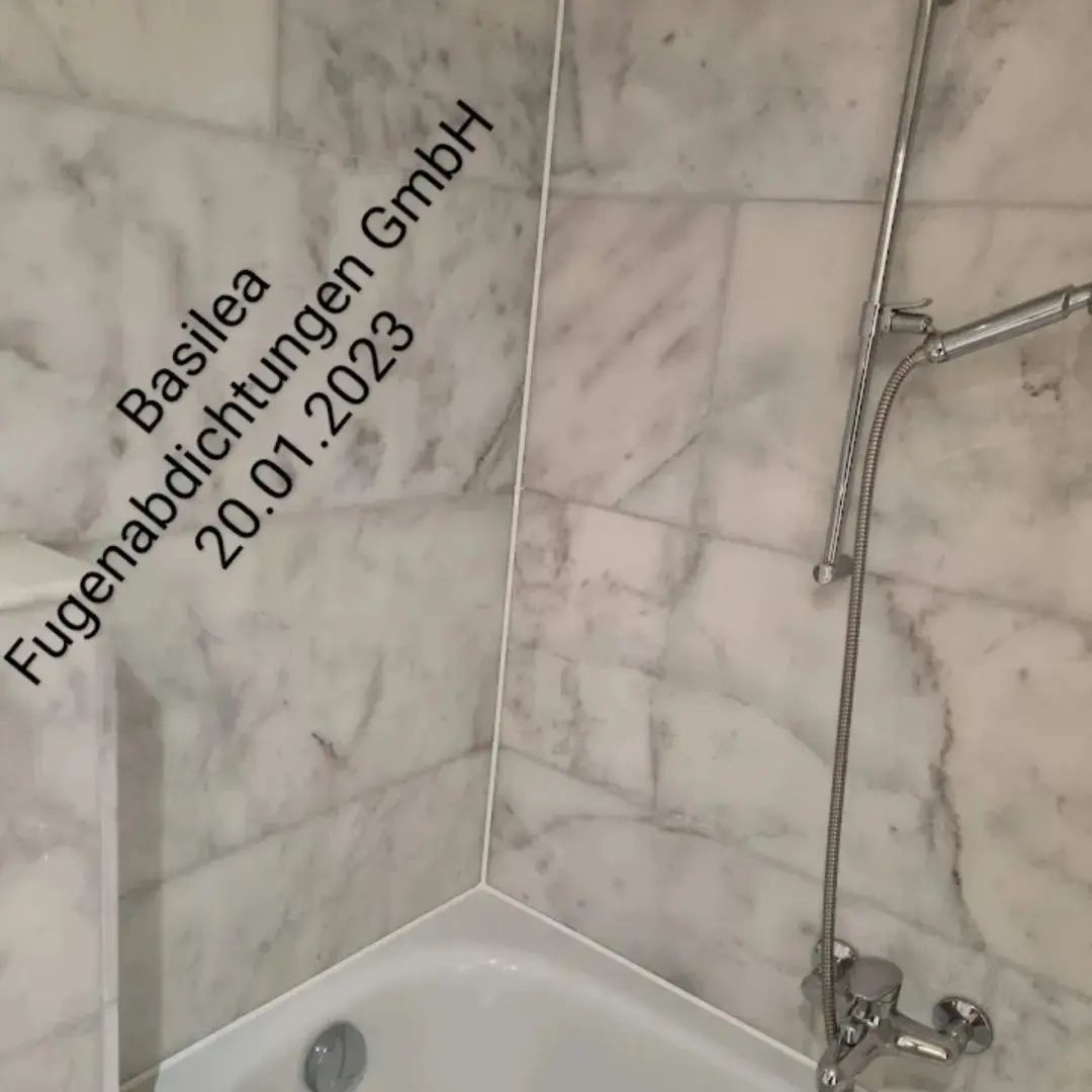 Ein Badezimmer mit Marmorfliesen und einer Badewanne mit dem Datum 20.01.2023 an der Wand