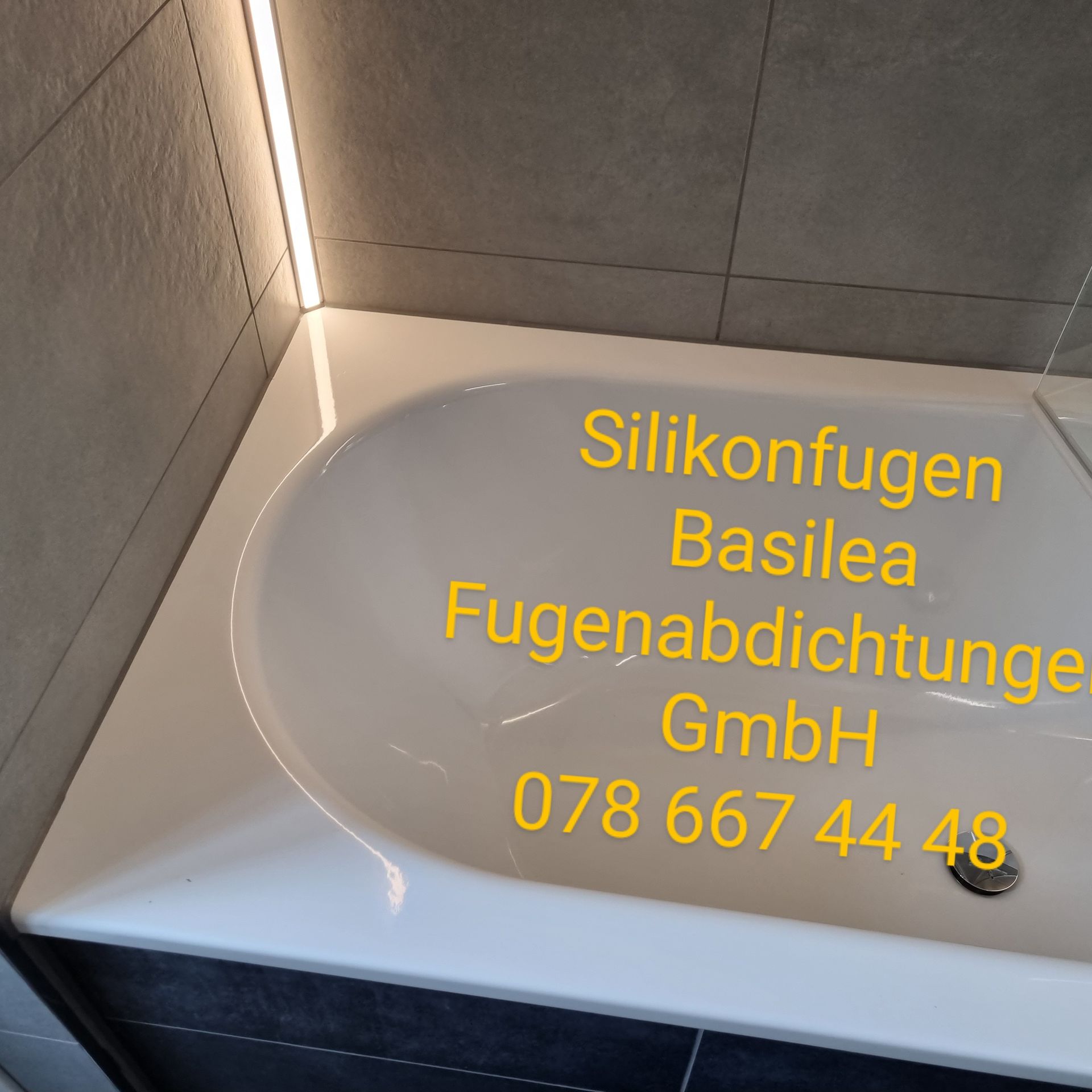 Eine weiße Badewanne mit der Aufschrift „Silikonfugen Basilea Fugenabdichtung GmbH“
