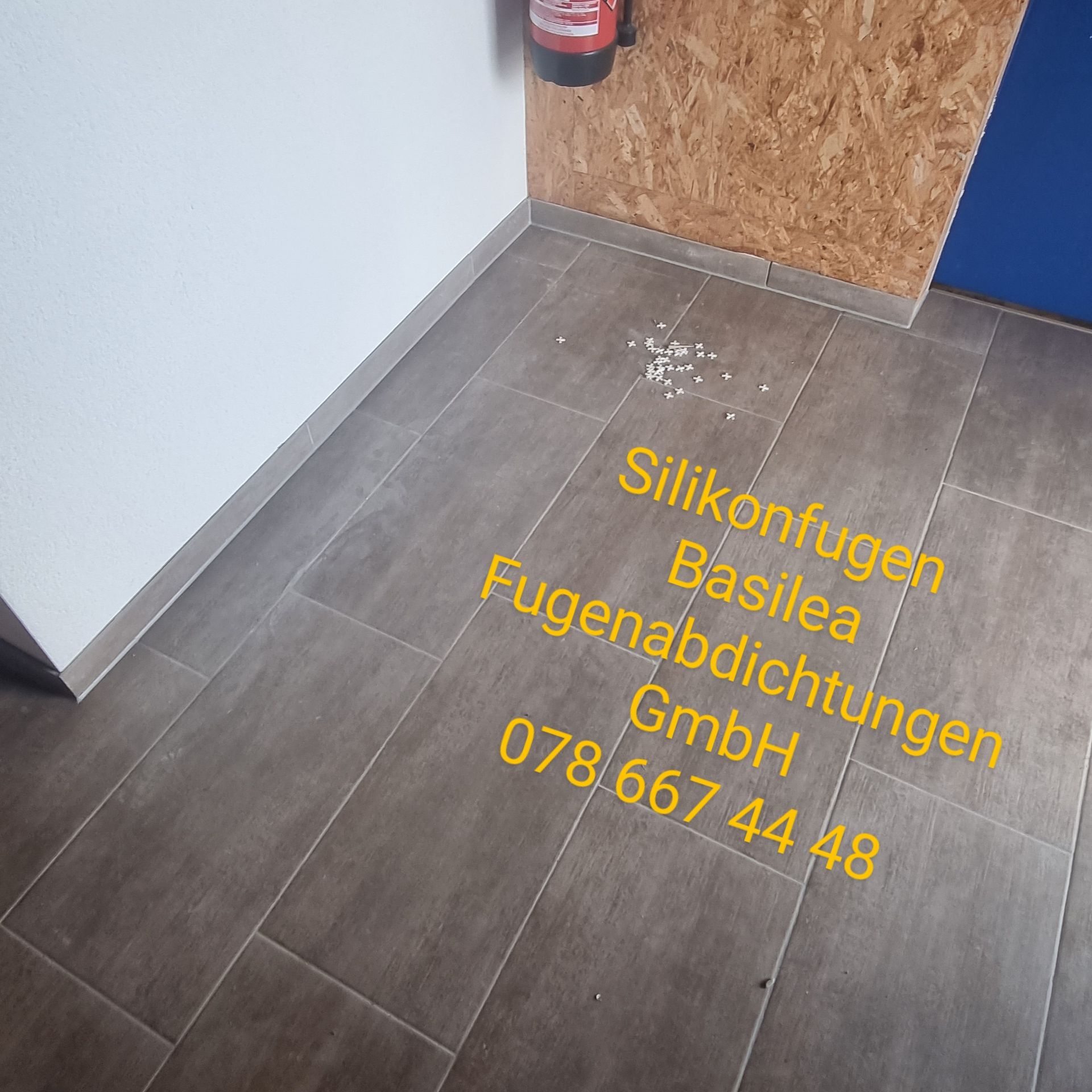Auf dem Boden steht ein Schild mit der Aufschrift „Silikonfugen Basilea“