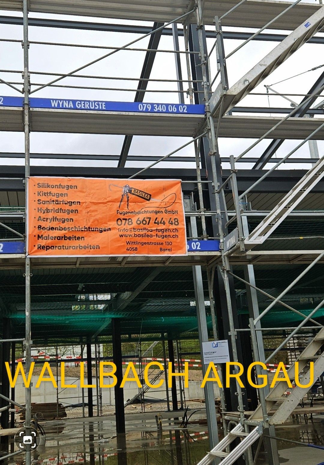 Ein im Bau befindliches Gebäude mit Gerüst und einem Schild darauf.