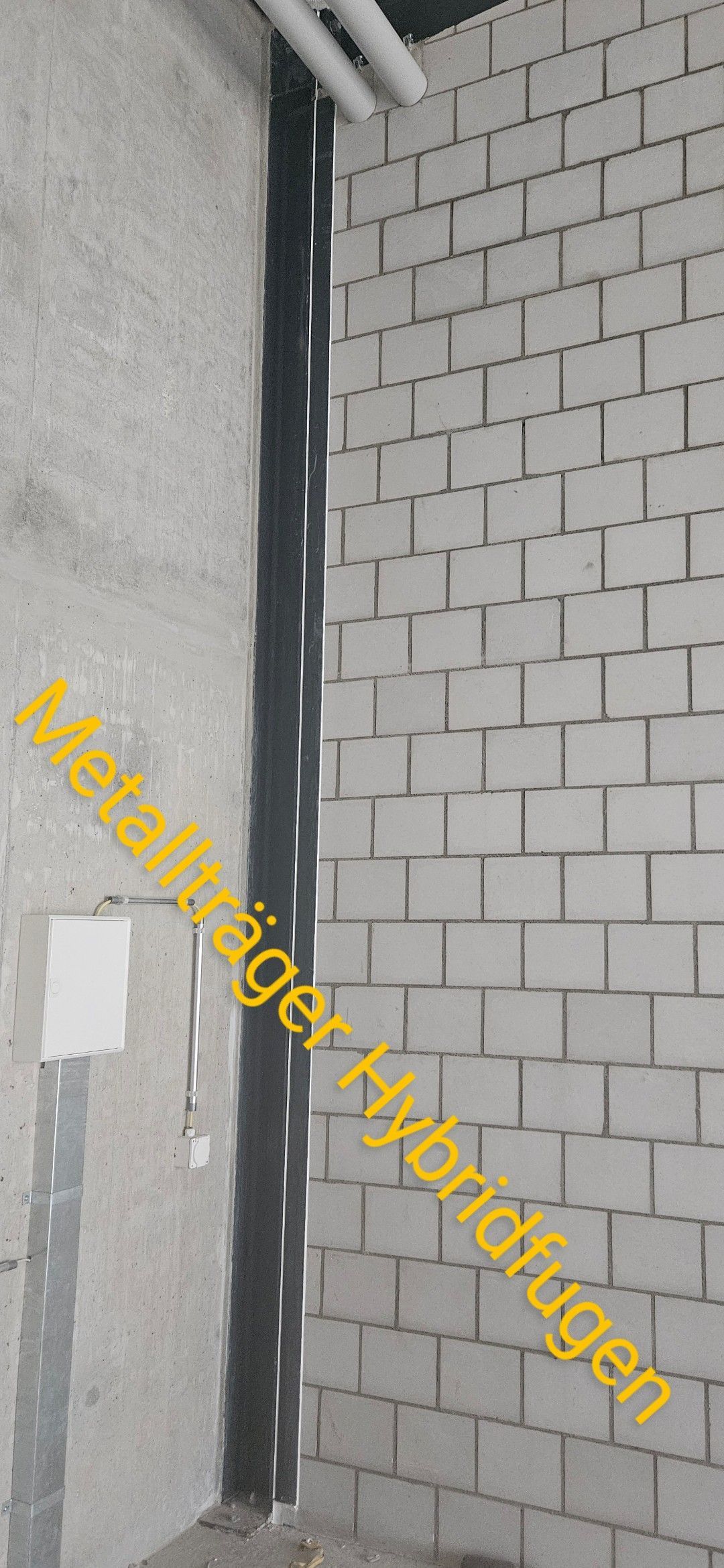 Eine Ziegelwand, durch die ein Metallrohr verläuft.