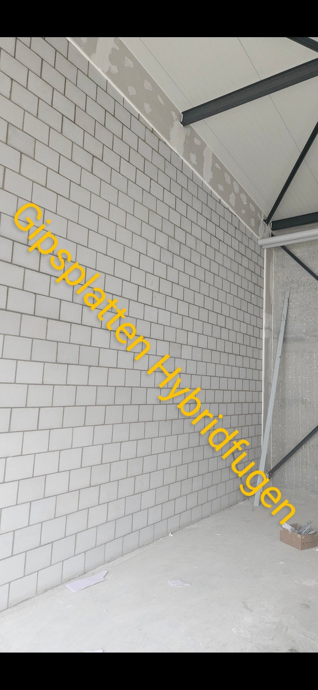 Ein Raum mit einer weißen Ziegelwand und einem gelben Schild an der Wand.