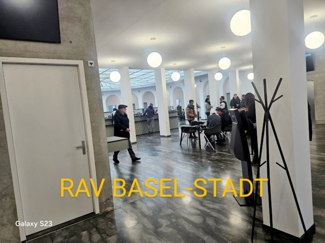 Eine Gruppe von Leuten sitzt in einem Raum an Tischen.