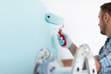 Maler streicht eine Wand mit einer Farbrolle