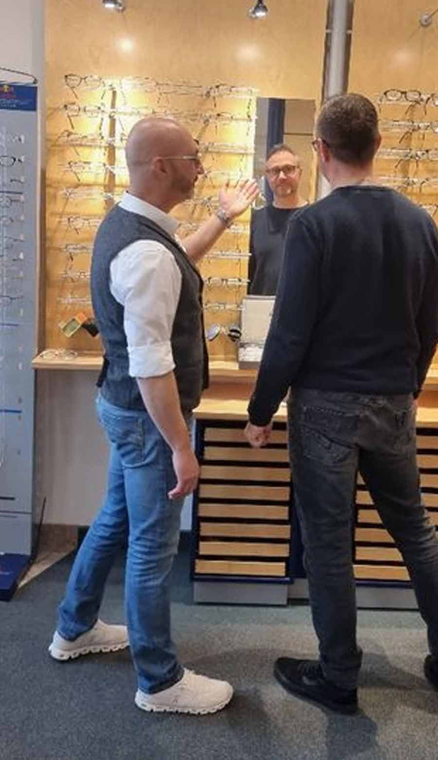 Zwei Männer stehen nebeneinander und schauen in einen Spiegel .