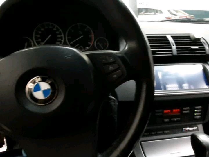 Vista interior del volante y el salpicadero de BMW con pantalla en la consola central.