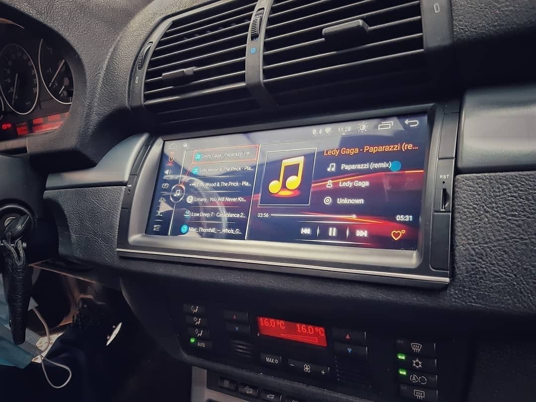 Tablero del automóvil con reproductor de música táctil que muestra una interfaz colorida e ícono de canción.