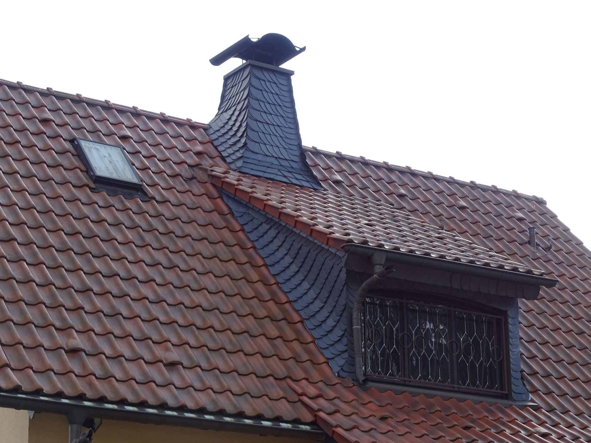 Ein weißes Haus mit einem roten Ziegeldach und einem blauen Himmel im Hintergrund