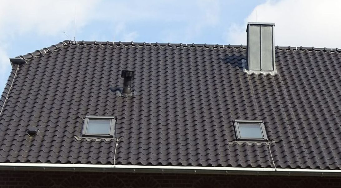 Ein Mann arbeitet auf dem Dach eines Hauses.