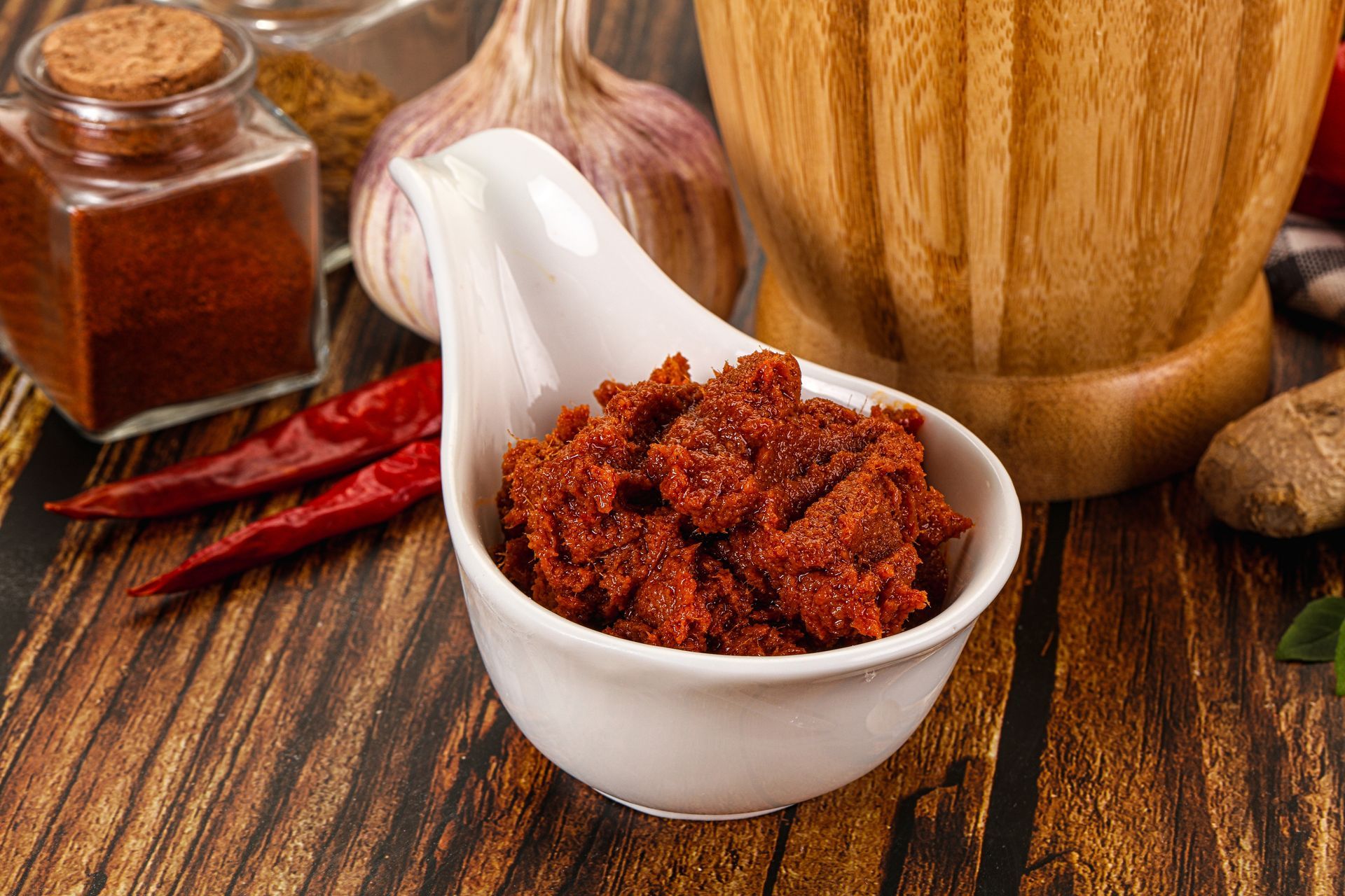 Tom Yum Paste in einer weissen Schale vor Chilis, Knoblauch und anderen Gewürzen im Thai Restaurant Rotkreuz.