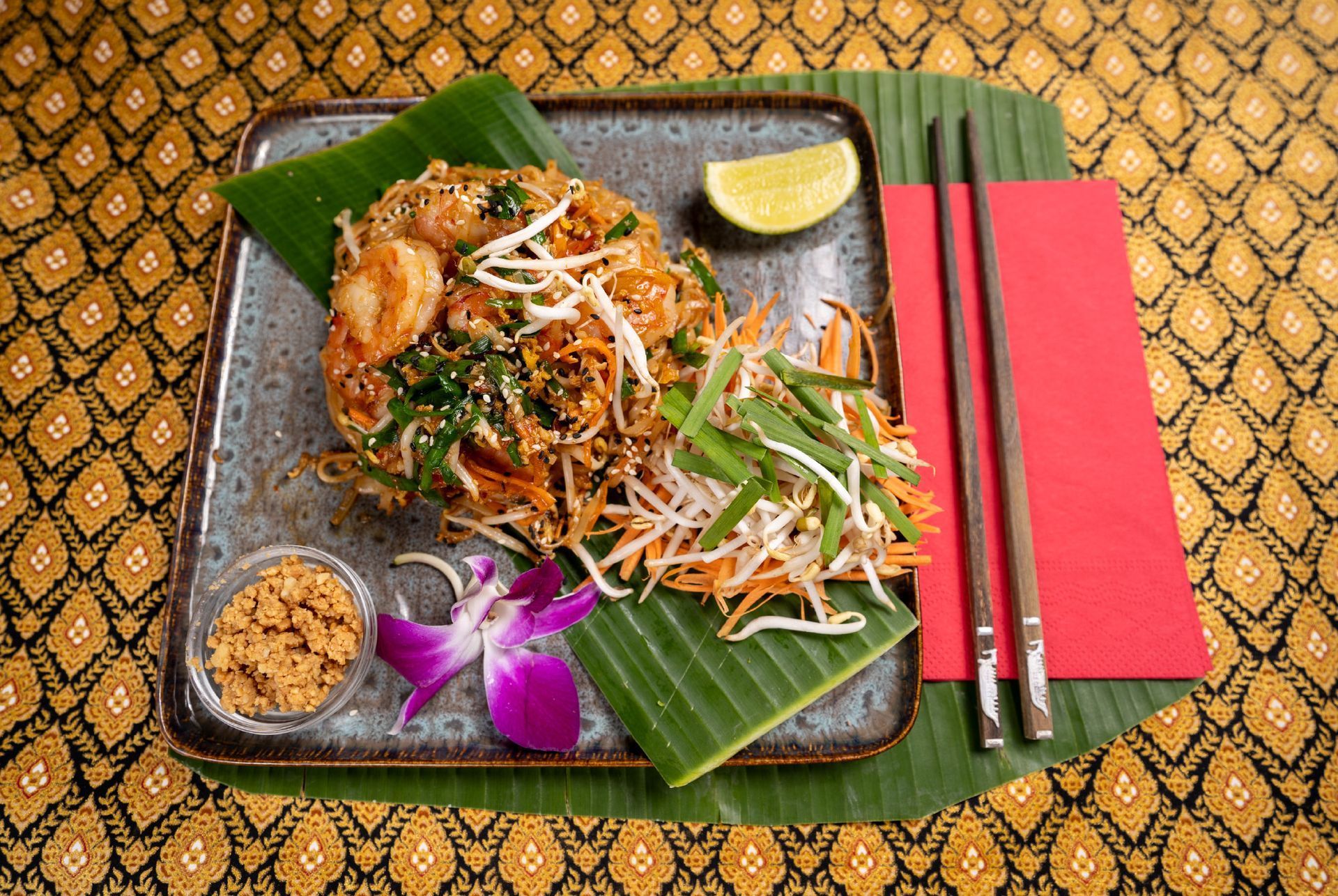 Pad Thai angerichtet auf einem Teller mit Stäbchen auf einer roten Serviette im Thai Restaurant Rotkreuz.