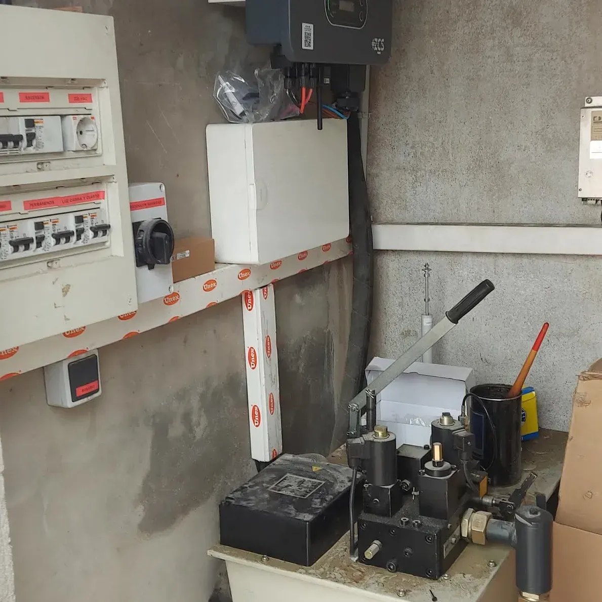 Cuadros eléctricos de control y cableado instalados en una pared de hormigón de una sala de servicio.