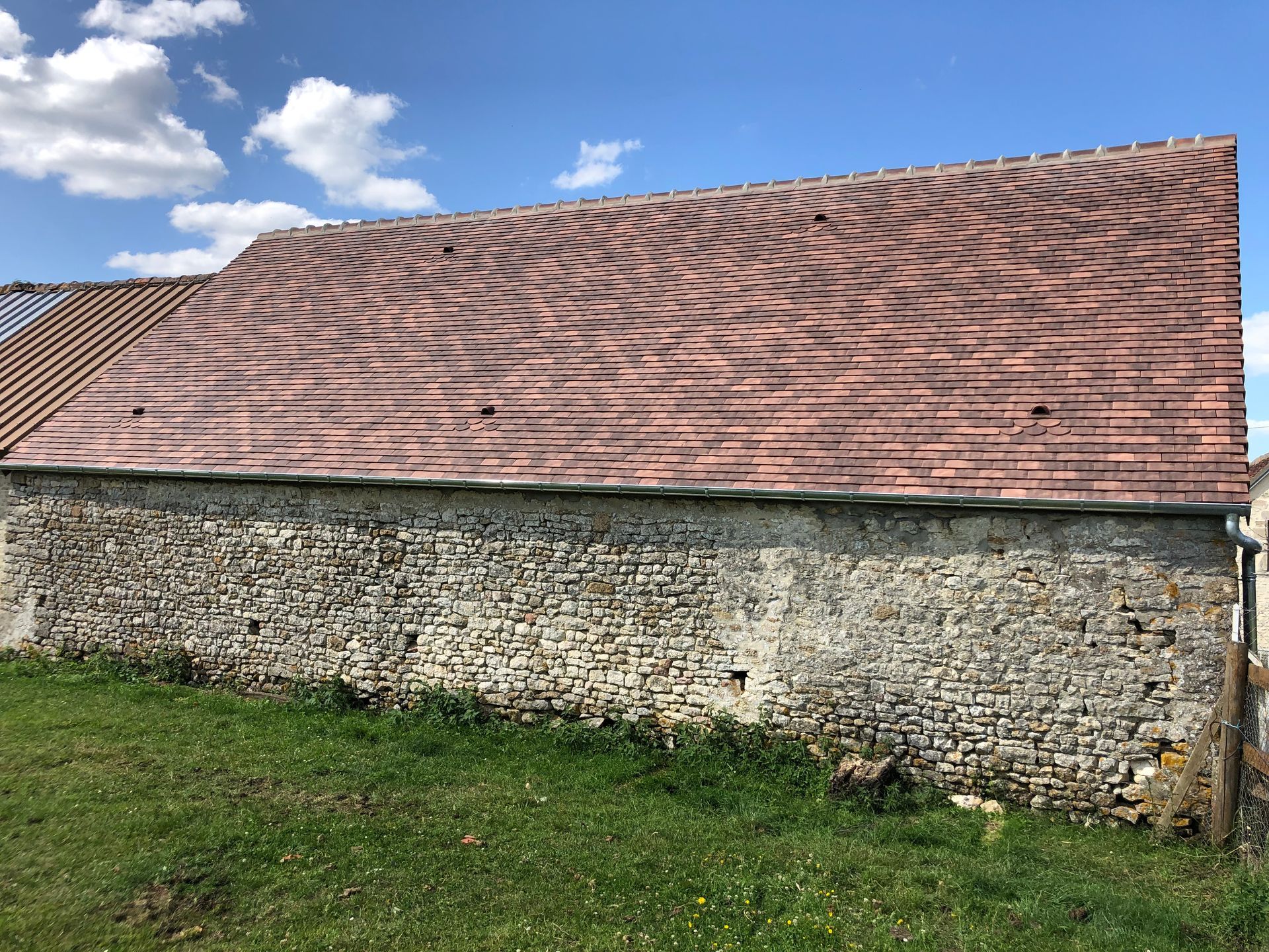 Un toit neuf sur un bâtiment en pierre apparente