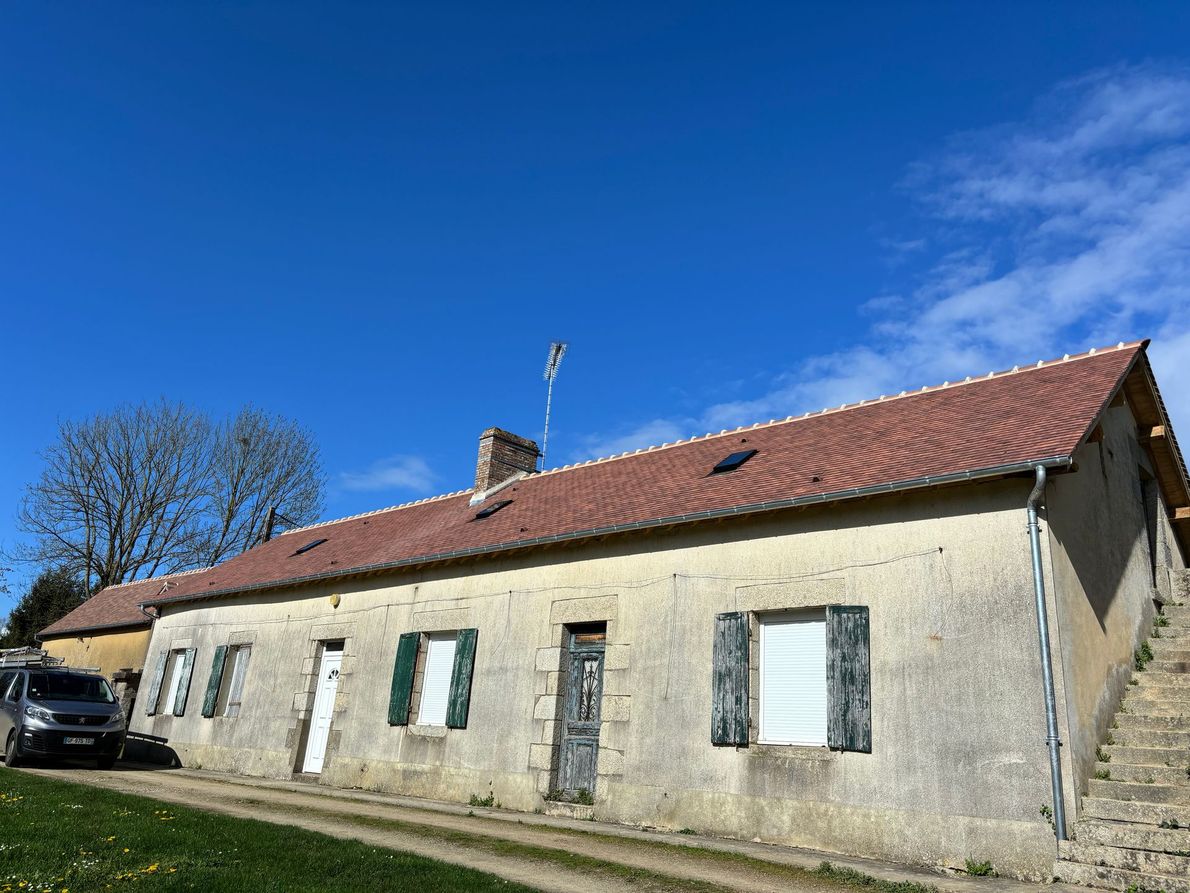 Une maison avec un toiture neuve et un ciel bleu