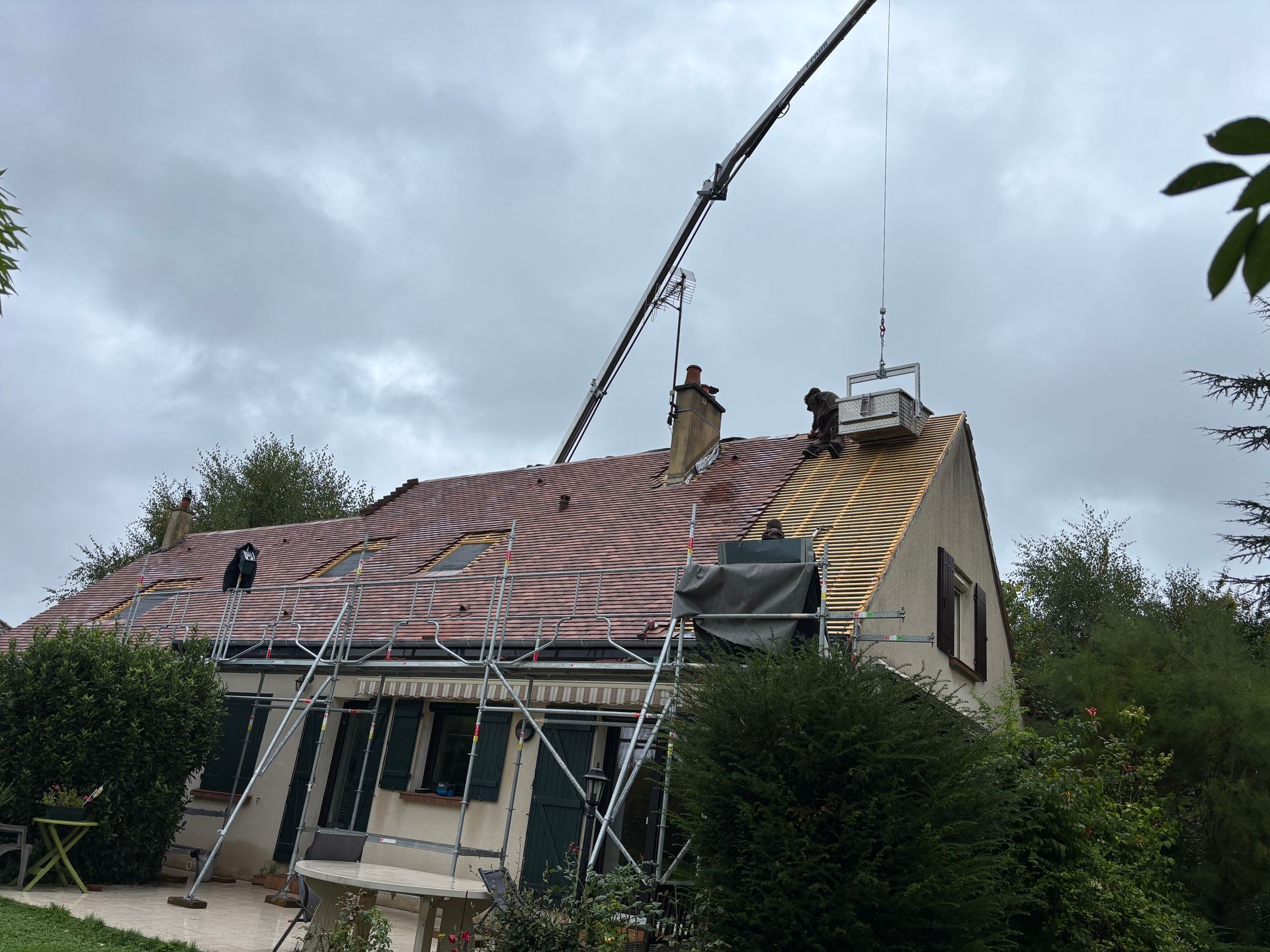 Une palette de tuile est déposée sur un toit