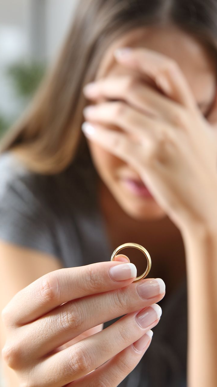 Femme tenant une alliance, se couvrant le visage