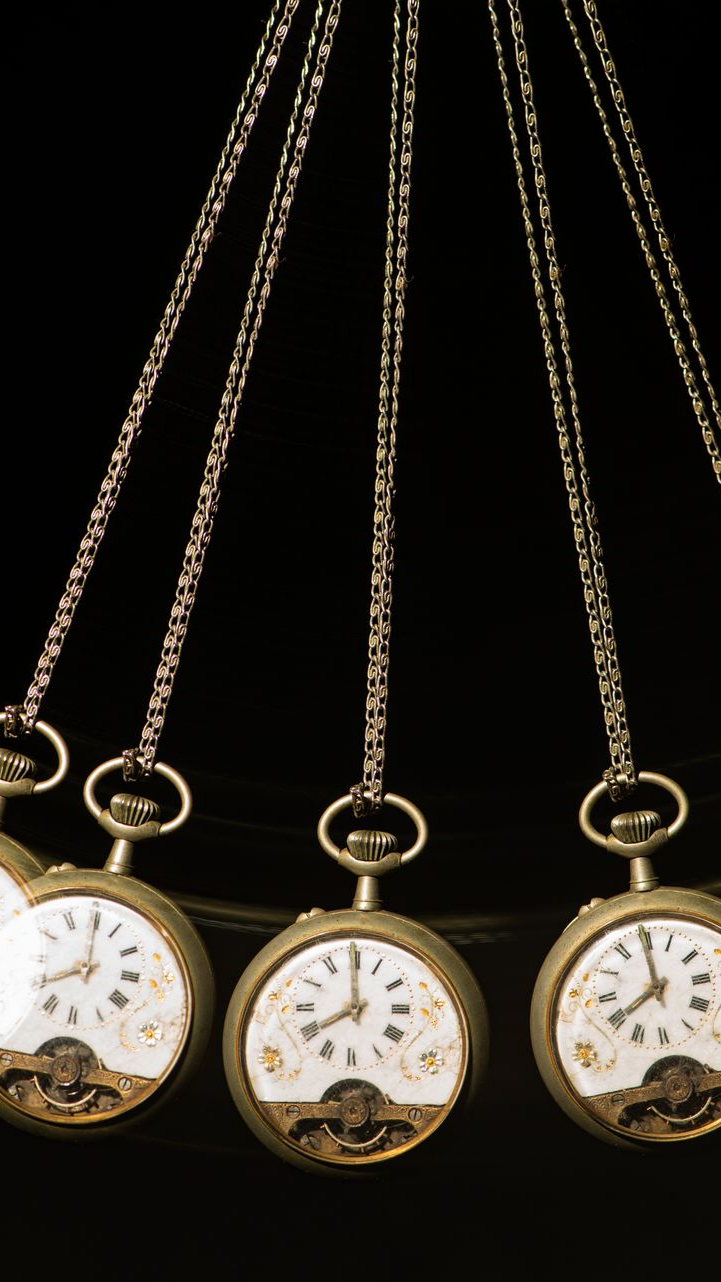 Montres de poche sur chaînes, se balançant sur un fond noir