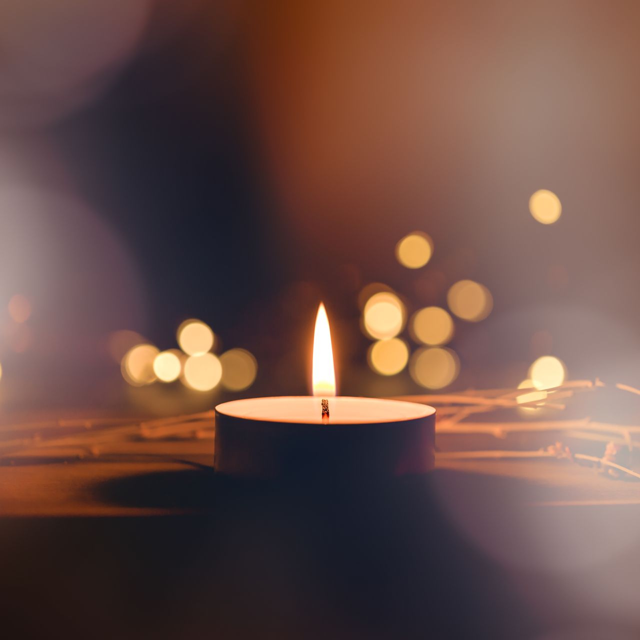 Une bougie chauffe-plat allumée projette une lueur chaleureuse