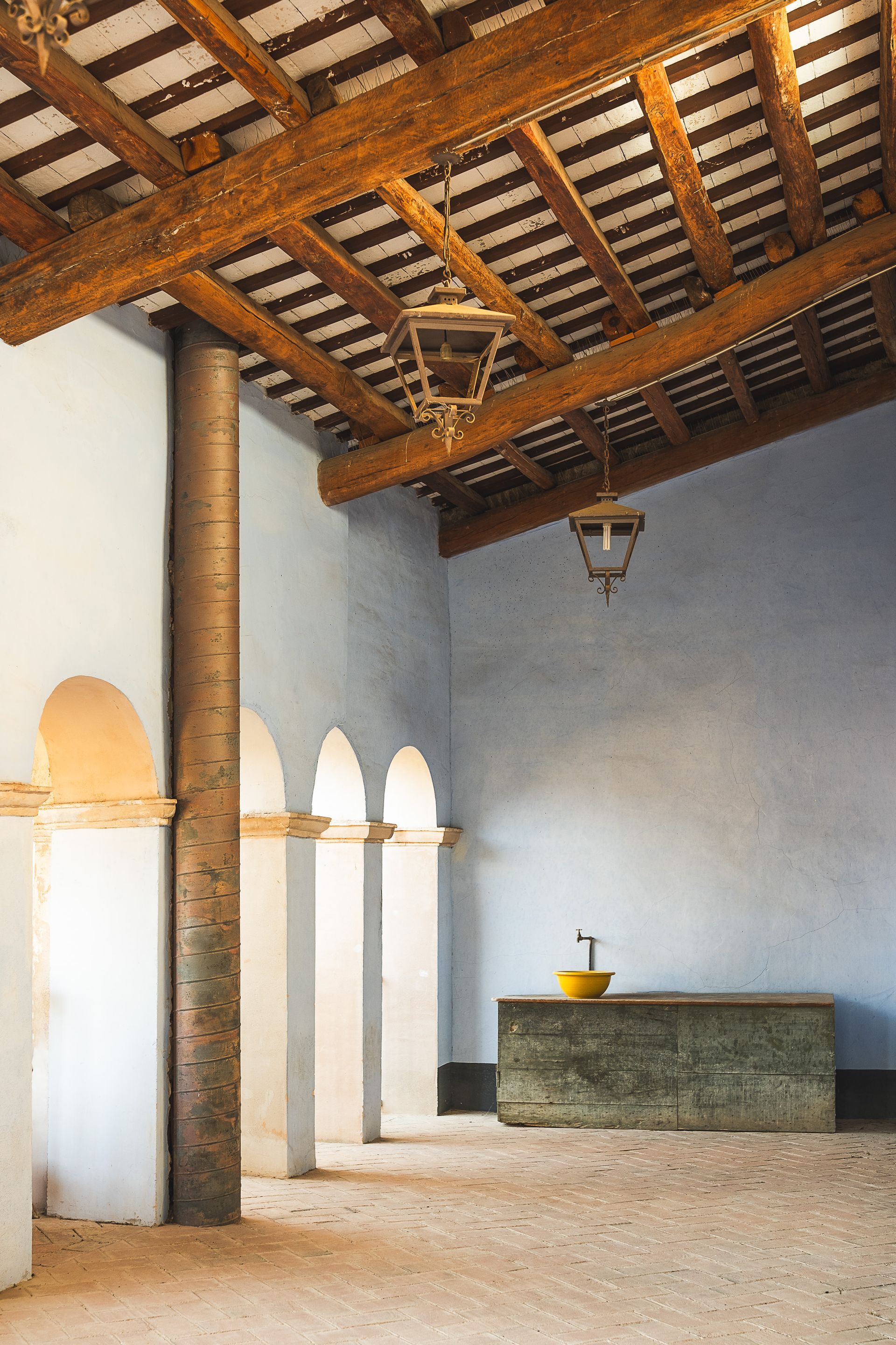 Una habitación con techo de madera y un lavabo en ella.