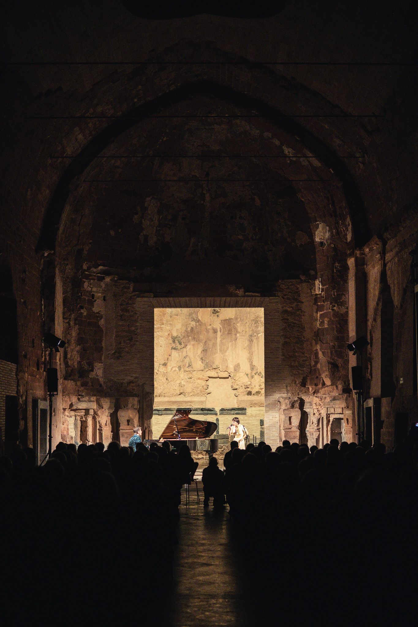 Un grupo de personas está de pie en una habitación oscura.