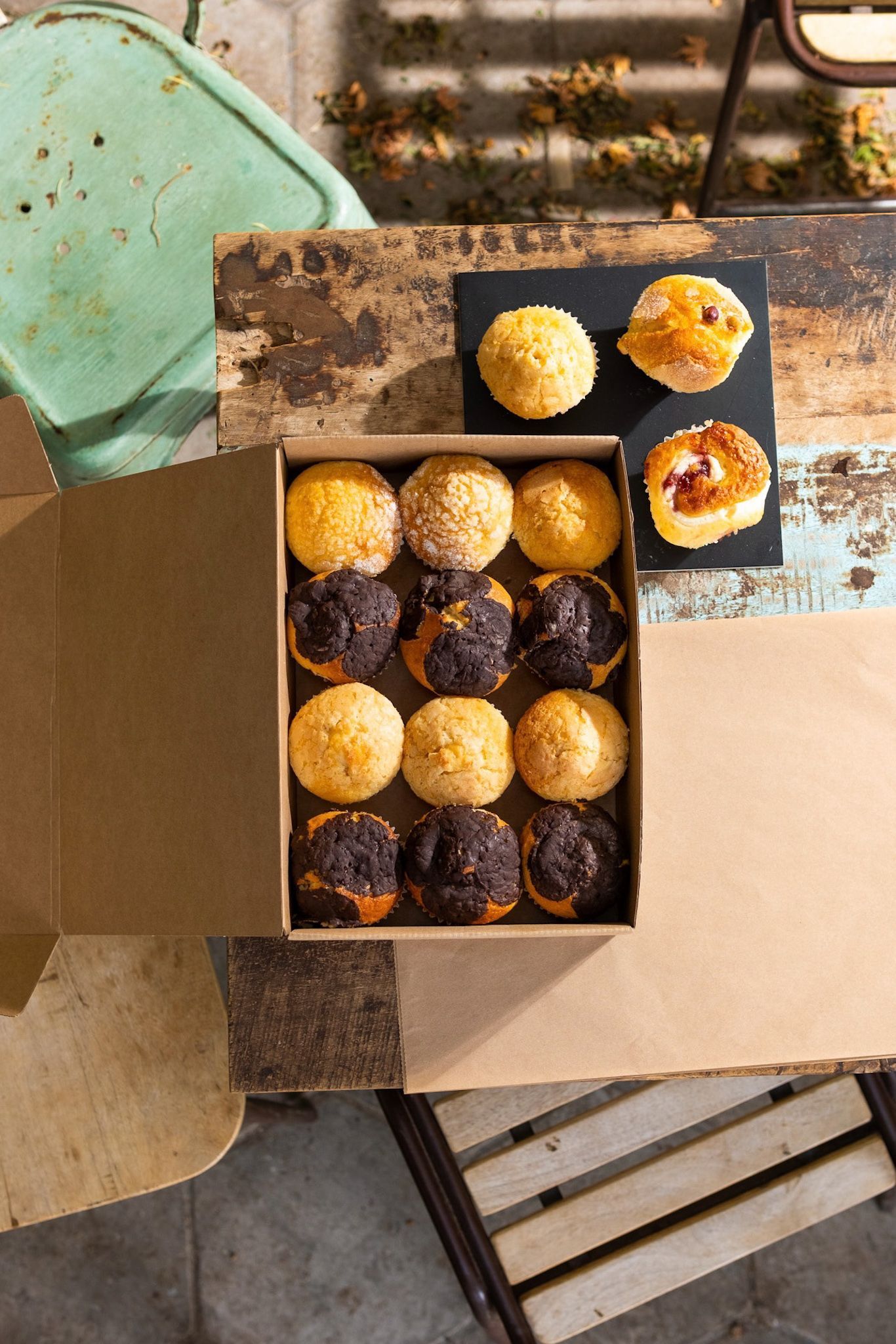Una caja de muffins está sobre una mesa de madera.
