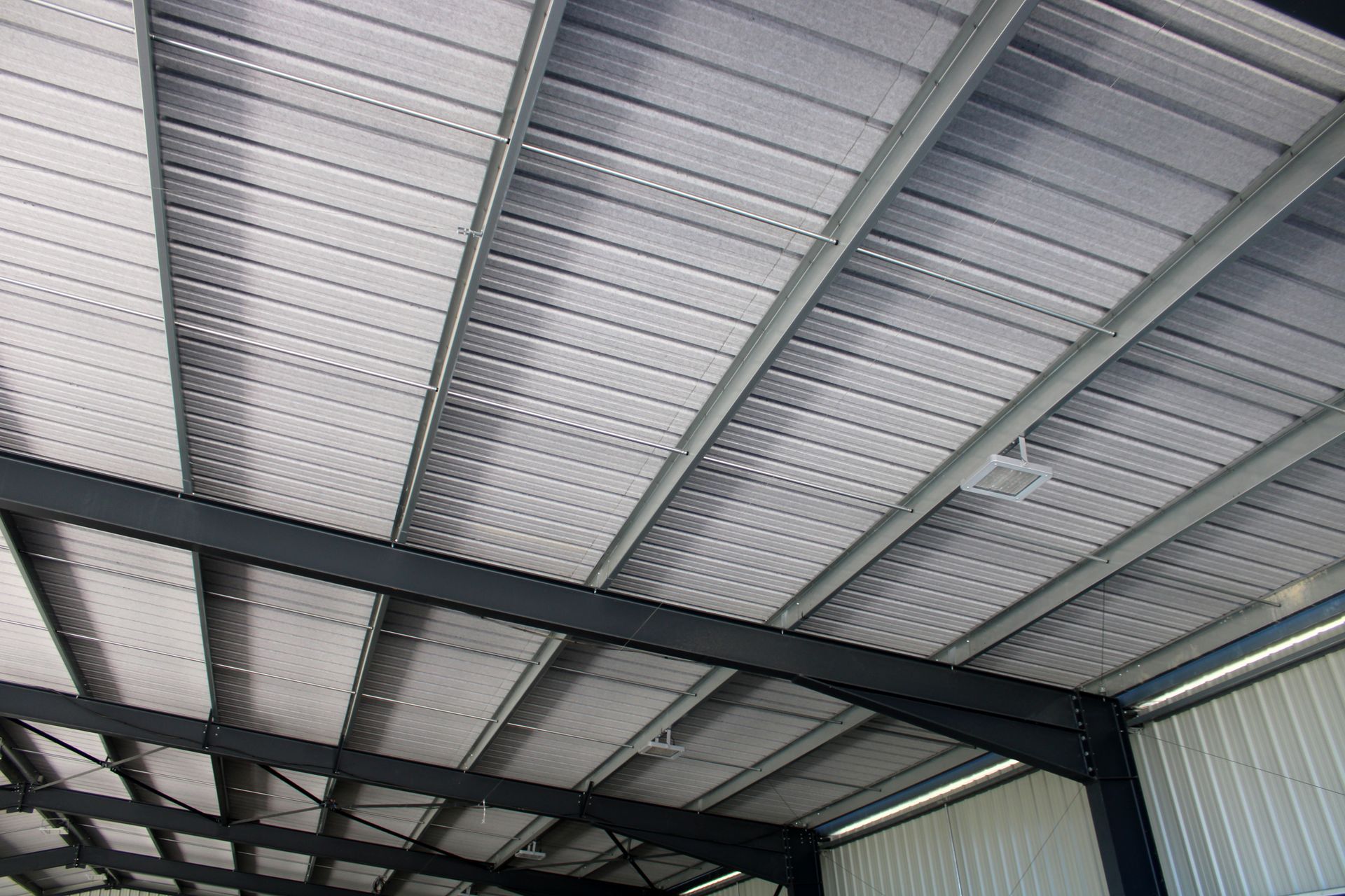 Charpente métallique intérieure et plafond en tôle ondulée dans un bâtiment de type entrepôt