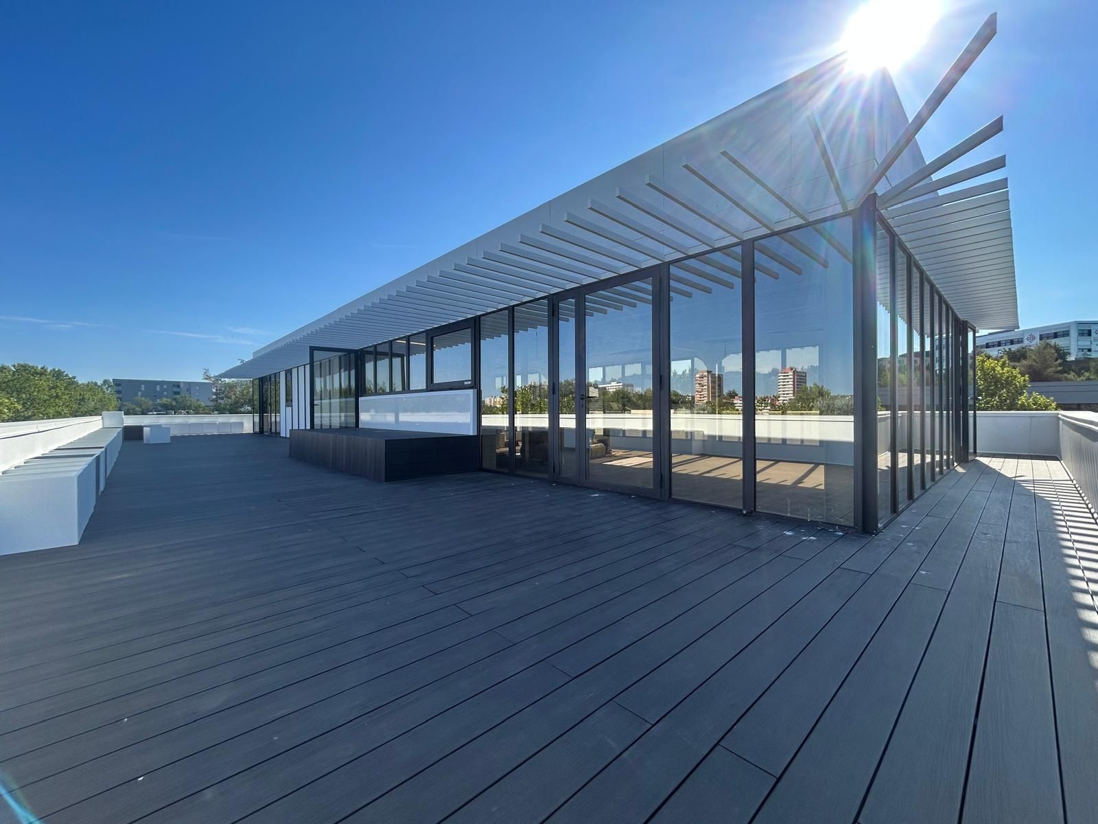 Terrasse moderne sur le toit avec pavillon de verre, terrasse à claire-voie et lumière naturelle abondante