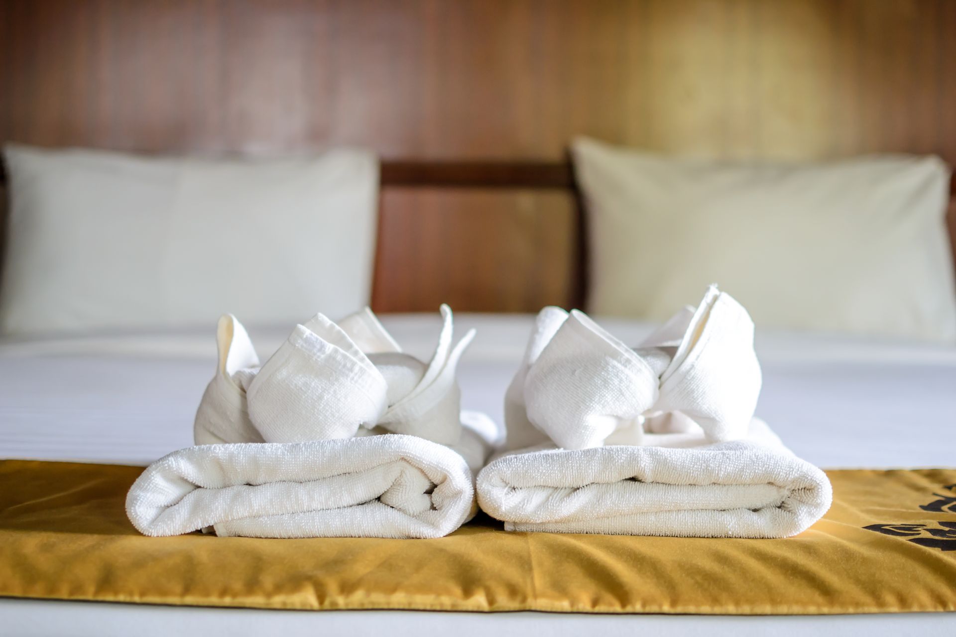 Dos toallas están apiladas una encima de otra en una cama.