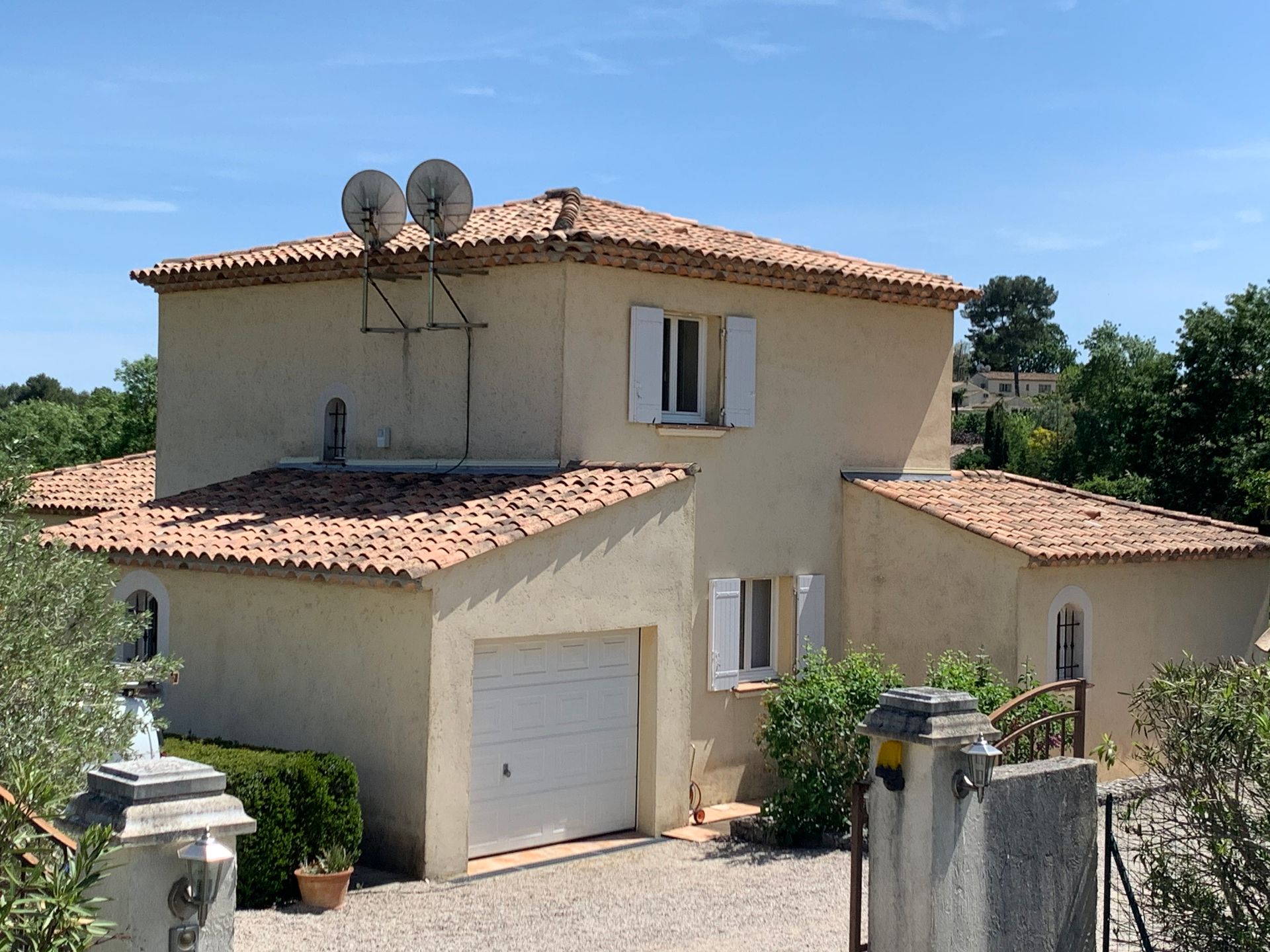 Photo d'une maison avec un garage avec la toiture entretenue