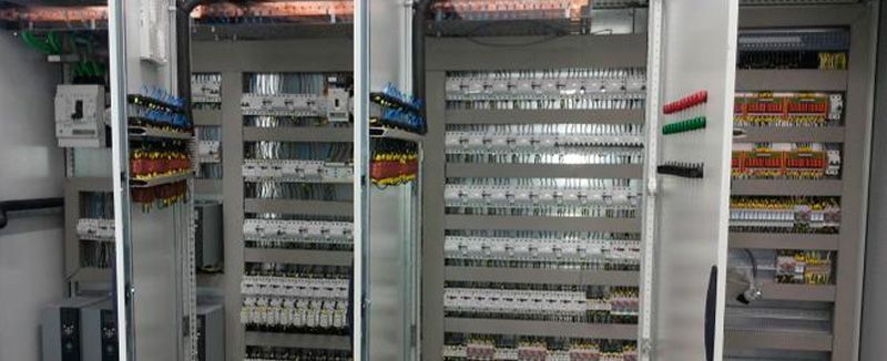 Paneles de control eléctrico con filas de disyuntores en un cuarto de servicio.