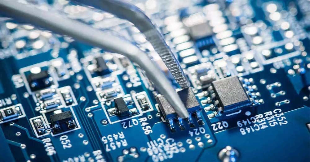 Primer plano de una placa de circuito azul con cables y componentes electrónicos.