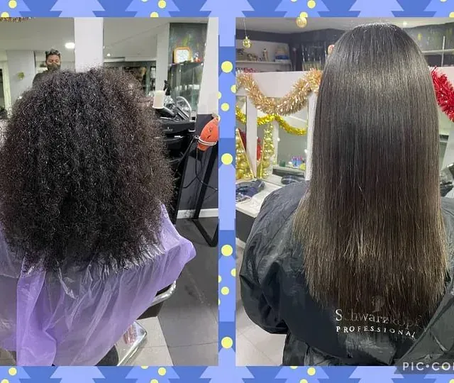 Una mujer se está alisando el cabello en una peluquería.